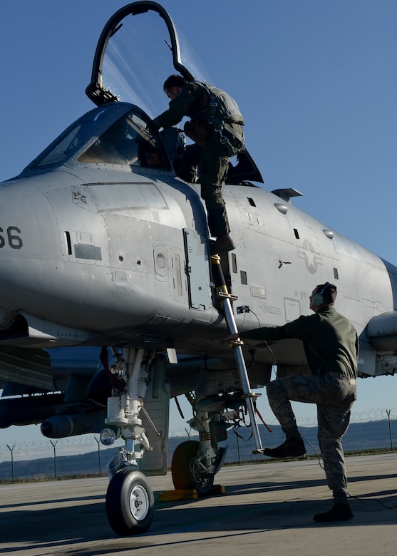A U.S. Air Force A-10 Thunderbolt II pilot assigned to the 354th Expeditionary Fighter Squadron enters the aircraft as a 354th EFS crew chief secures the aircraft's ladder during a theater security package deployment at Campia Turzii, Romania, April 1, 2015. The aircraft will conduct training alongside NATO allies to strengthen interoperability and demonstrate U.S. commitment to the security and stability of Europe.  (U.S. Air Force photo by Staff Sgt. Joe W. McFadden/Released)