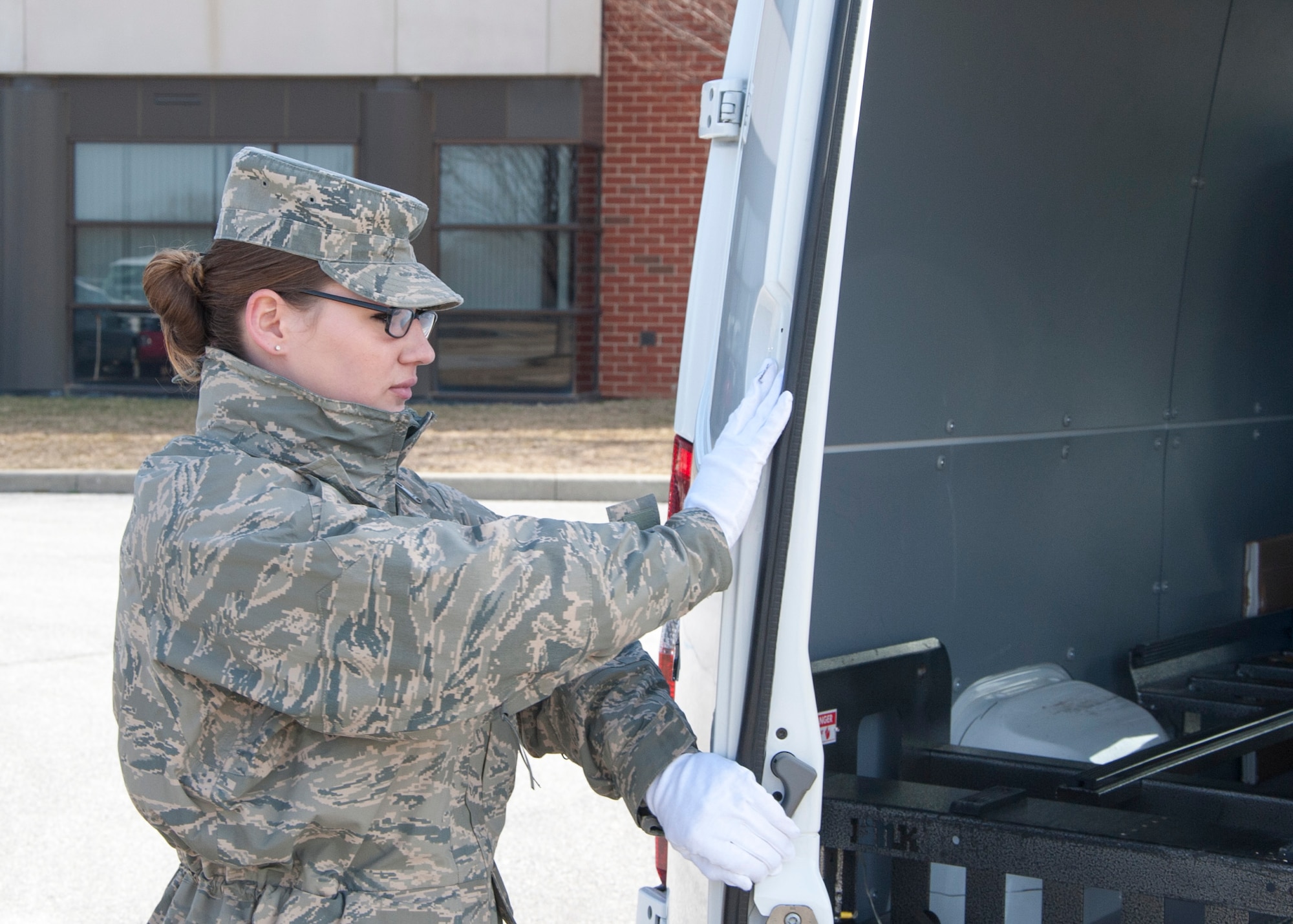 Senior Airman Jamie Debbrecht, a 512th Memorial Affairs Squadron services specialist, practices her role as door guard prior to the start of a dignified transfer divert exercise March 19, 2015, at New Castle Air National Guard Base, Del. Debbrecht is deployed to Air Force Mortuary Affairs Operations from the 512th Memorial Affairs Squadron, Dover Air Force Base, Del. (U.S. Air Force photo/Senior Airman Jared Duhon)