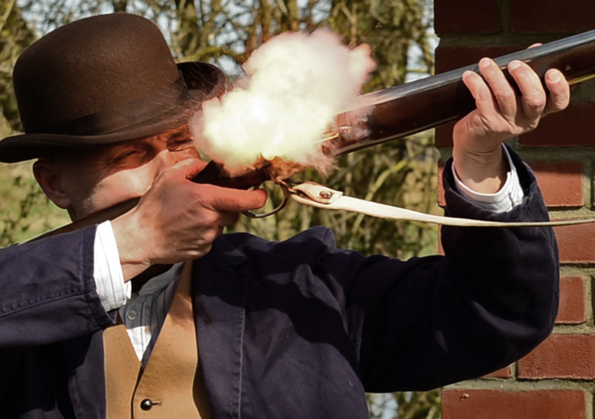 Nigel Amies, Norfolk Museum Service historical educator, demonstrates firing a flintlock musket at Royal Air Force Lakenheath, England, March 27, 2015. The demonstration was part of a three-week pioneer life simulation for 4th and 5th grade Liberty Intermediate School students studying the colonial period. (U.S. Air Force photo by Airman 1st Class Erin R. Babis/Released)