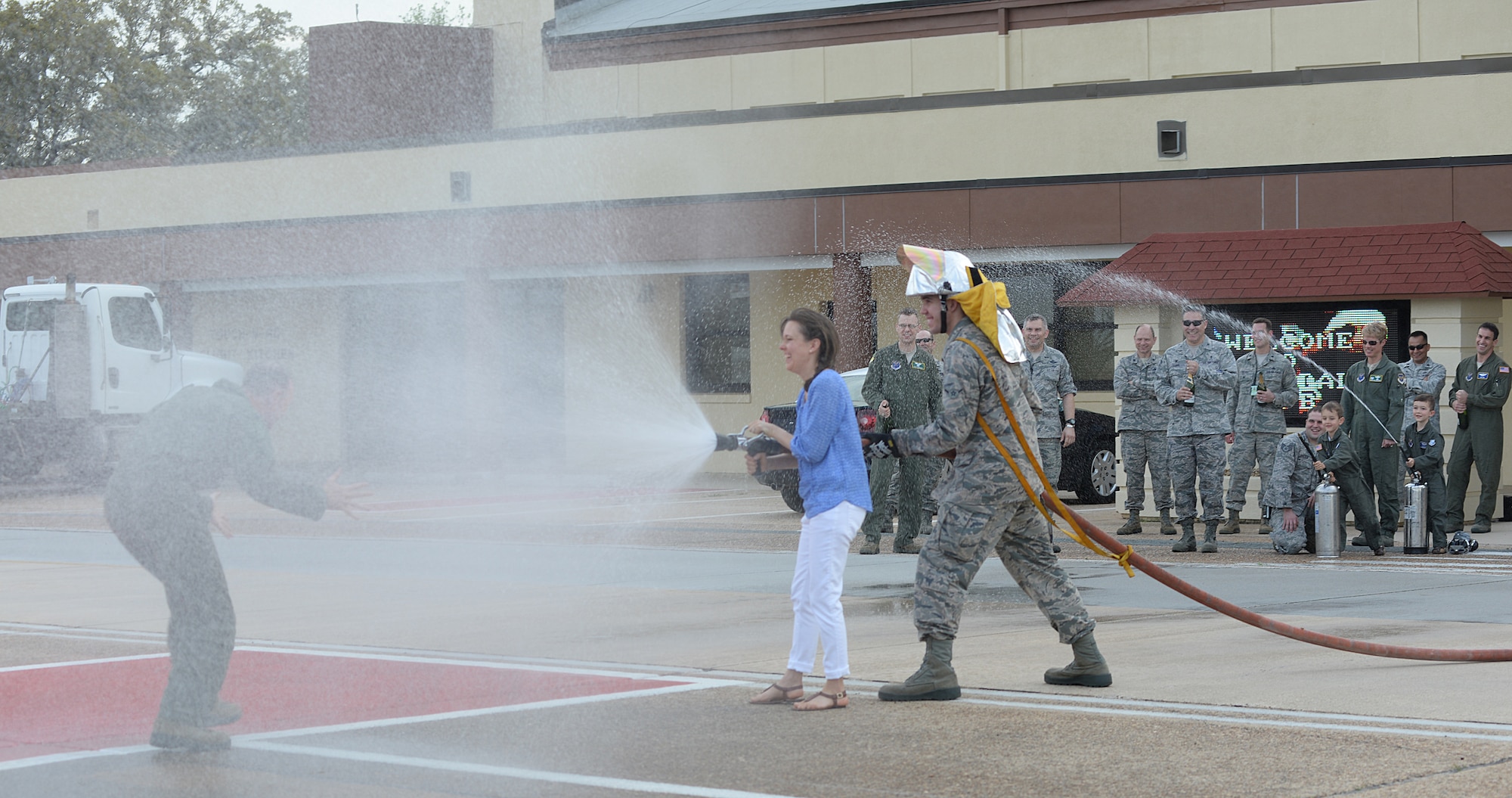 Col. Leland Bohannon, 2nd Bomb Wing vice commander, is hosed down by his wife after completing his final flight mission on Barksdale Air Force Base, La., April 1, 2015. The "fini flight" is a momentous occasion in an aviator's career, signaling their final flying mission. As the aviator exits the aircraft, family members will hose him down with water. (U.S. Air Force photo/Senior Airman Benjamin Gonsier)