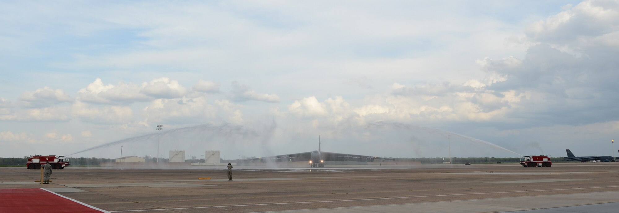 Col. Leland Bohannon, 2nd Bomb Wing vice commander, maneuvers a B-52H Stratofortress through water being sprayed by fire trucks after his "fini flight" on Barksdale Air Force Base, La., April 1, 2015. It is a tradition for fire trucks to join the crowd in welcoming the aviator back from his final flight with a spray down. (U.S. Air Force photo/Senior Airman Benjamin Gonsier)