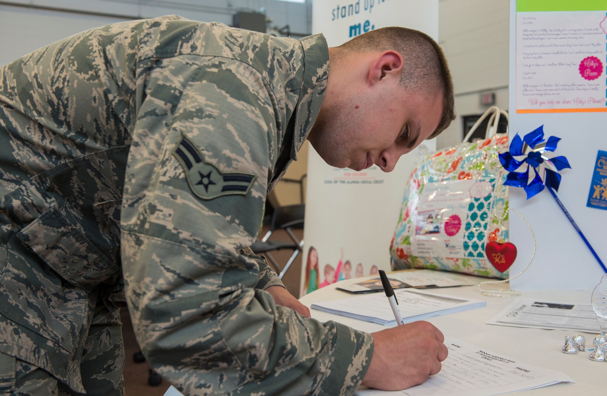 U.S. Air Force Airman 1st Class Cody Masterson, 23d Logistics Readiness Squadron material management specialist, signs up to volunteer during the Volunteer Fair April 1, 2015, at Moody Air Force Base, Ga. The different volunteer options available were a combination of organizations on base and in the local area. (U.S. Air Force photo by Airman 1st Class Ceaira Tinsley/Released)