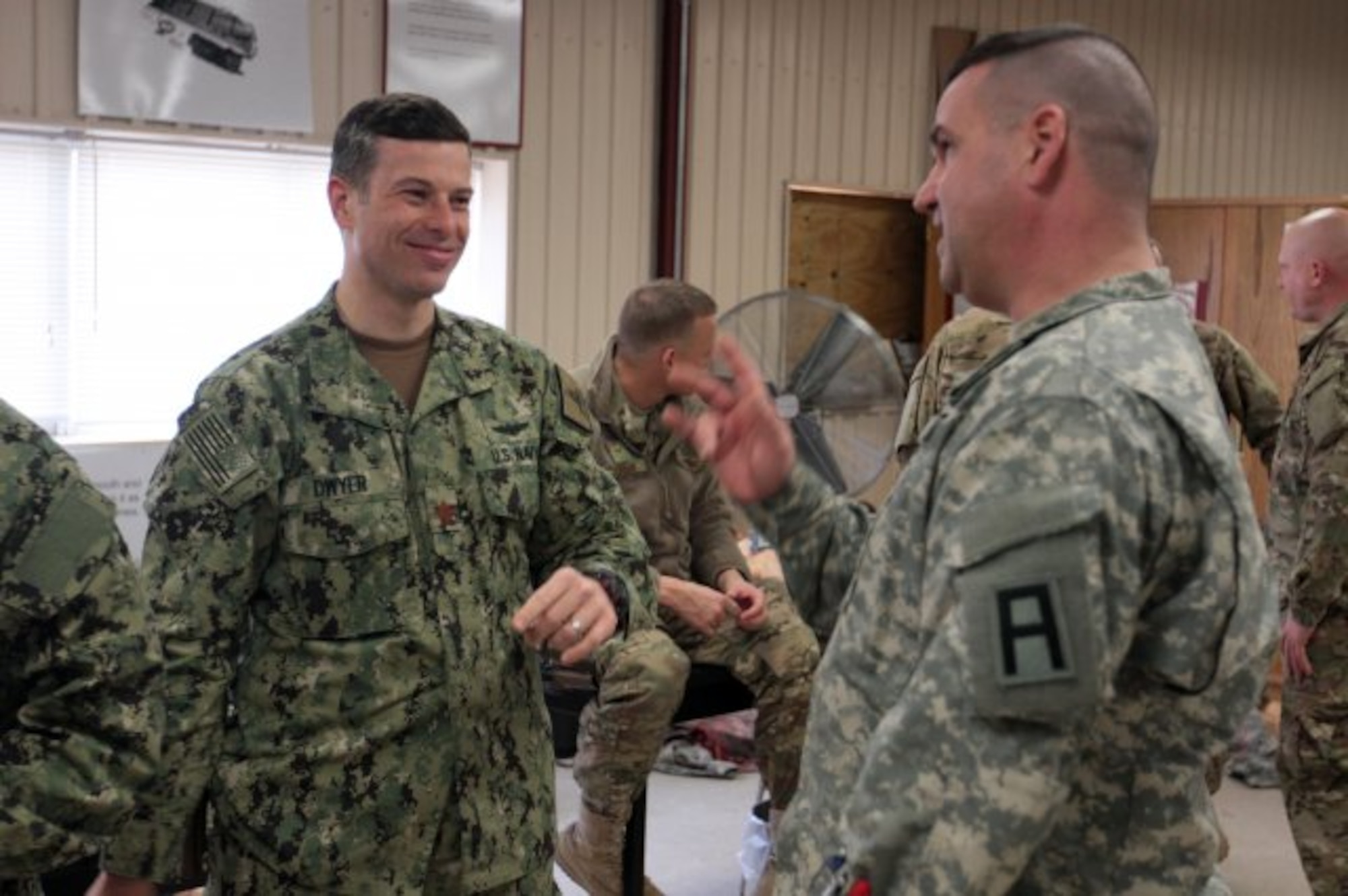 Army Staff Sgt. Leon Miles, a combat lifesaver instructor with the 174th Infantry Brigade at Joint Base McGuire-Dix-Lakehurst and Lt. Cmdr. Peter Dwyer share deployment experiences during a CLS class. This CLS class was a joint training session in which Army medics trained Air Force and Navy personnel preparing to deploy how to provide potentially lifesaving aid on the battlefield.
