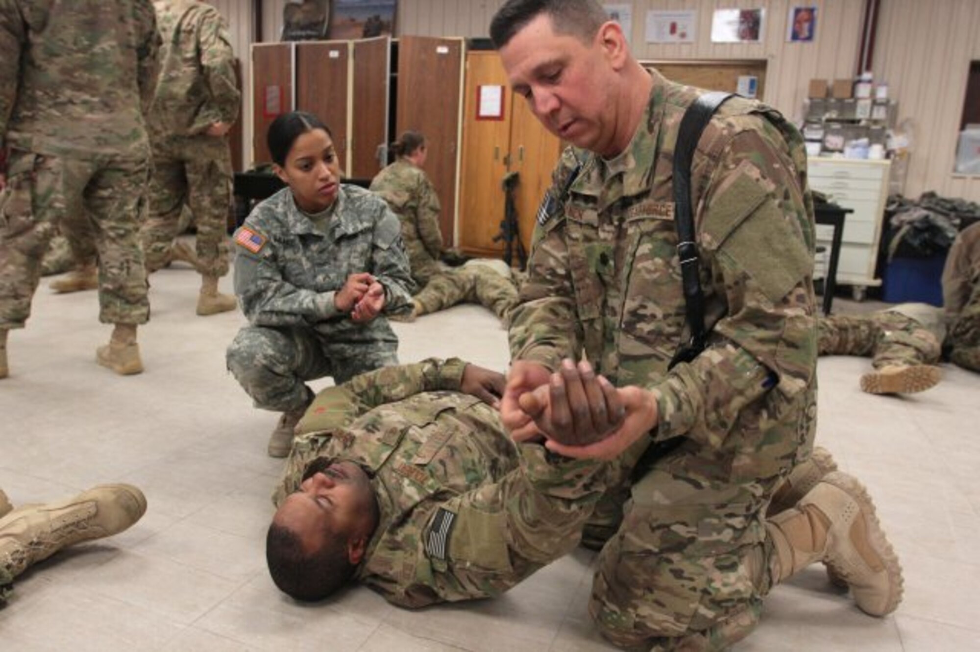 Army Cpl. Erica Muniz, a combat lifesaver instructor with the 174th Infantry Brigade at Joint Base McGuire-Dix-Lakehurst coaches Air Force Lt. Col. Roger Lynch on how to properly check for a pulse on a casualty during a CLS class. This CLS class was a joint training session in which Army medics trained Air Force and Navy personnel preparing to deploy how to provide potentially lifesaving aid on the battlefield.