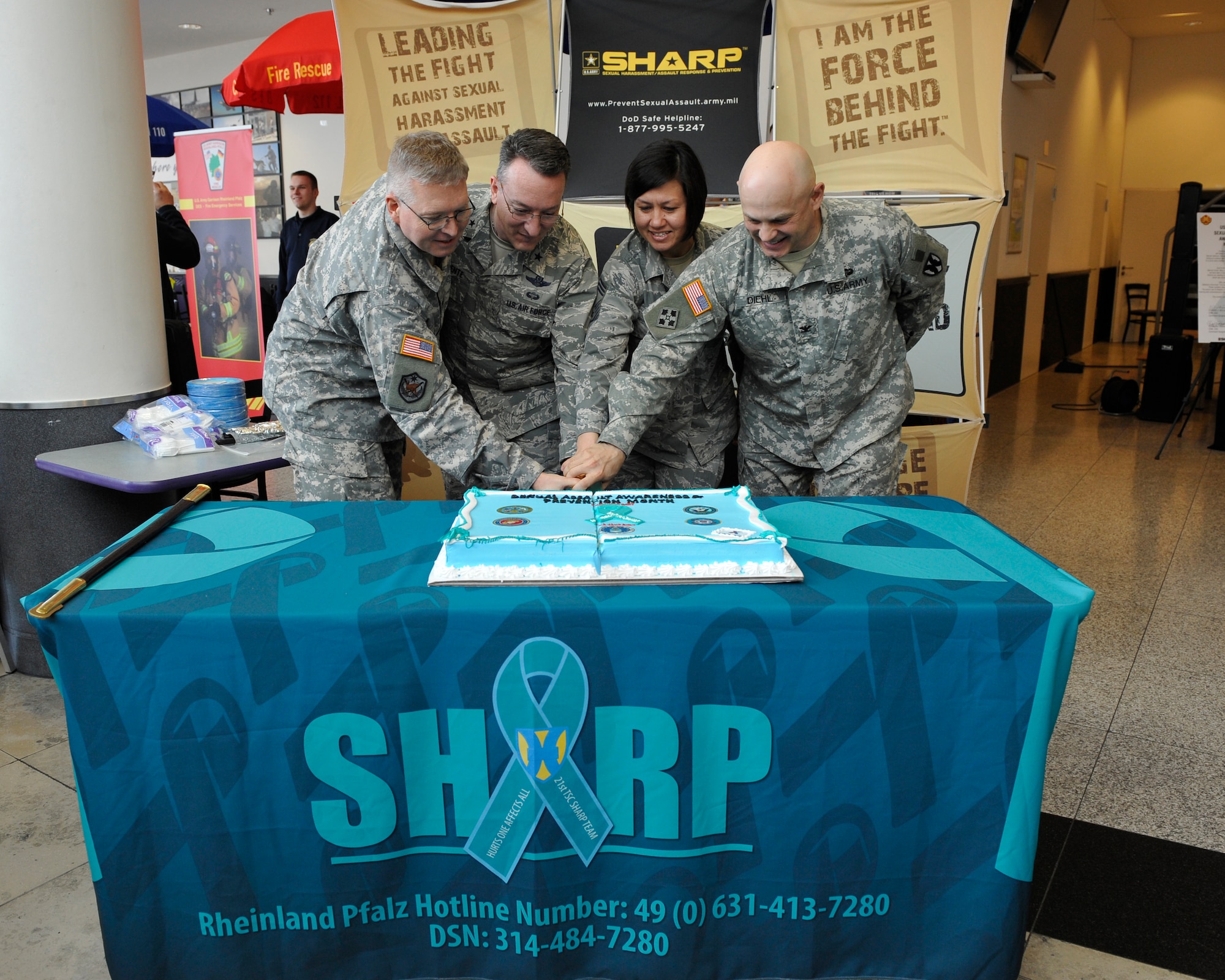 Brig. Gen. Patrick X. Mordente, 86th Airlift Wing commander, second from left, Col. Shawn Wells, U.S. Army Garrison Rheinland-Pfalz commander, Chief Master Sgt. Joanne Bass, 86th Operations Group superintendent, and Col. Barry Diehl, USAG Rheinland-Pfalz deputy commander, cut a cake at the Sexual Assault Awareness and Prevention Month kickoff event April 1, 2015 at Kaiserslautern Military Community Center food court on Ramstein Air Base, Germany. The month focuses on ensuring Airmen and families are aware of the resources available to aid in the prevention of sexual assault and the different types of reporting procedures available. (U.S. Air Force photo/Staff Sgt. Leslie Keopka)