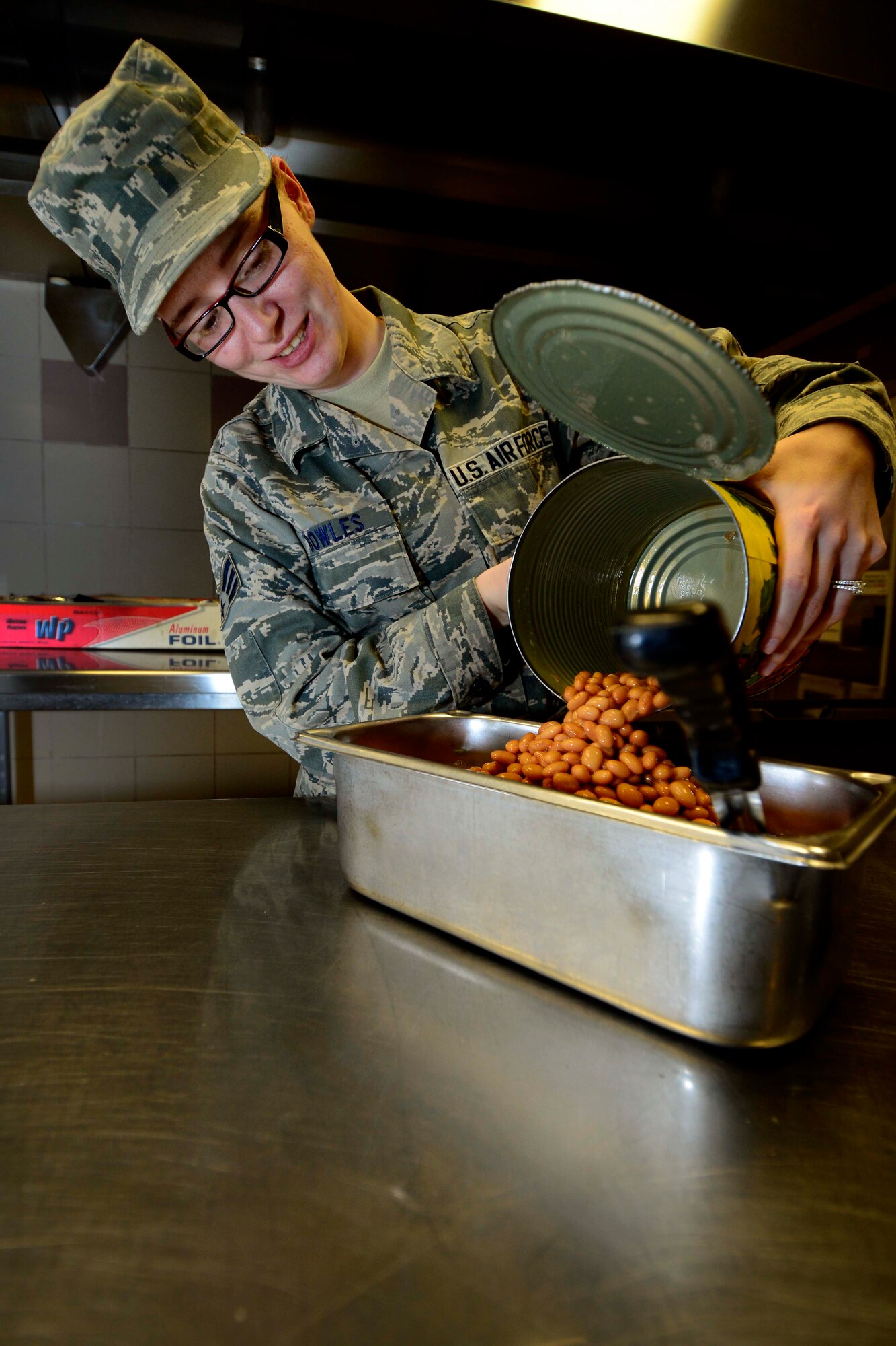 U.S. Air Force Senior Airman Angela Bowles, 31st Force Support Squadron food services journeyman, prepares beans before lunch is served, April 1, 2015 at Aviano Air Base, Italy. La Dolce Vita aims to make it easier for Airmen, who are unable to leave their work area to get a hot meal or something quick on the go by offering a Grab-N-Go Expanded Flight Kitchen. (U.S. Air Force photo by Senior Airman Areca T. Wilson/Released)