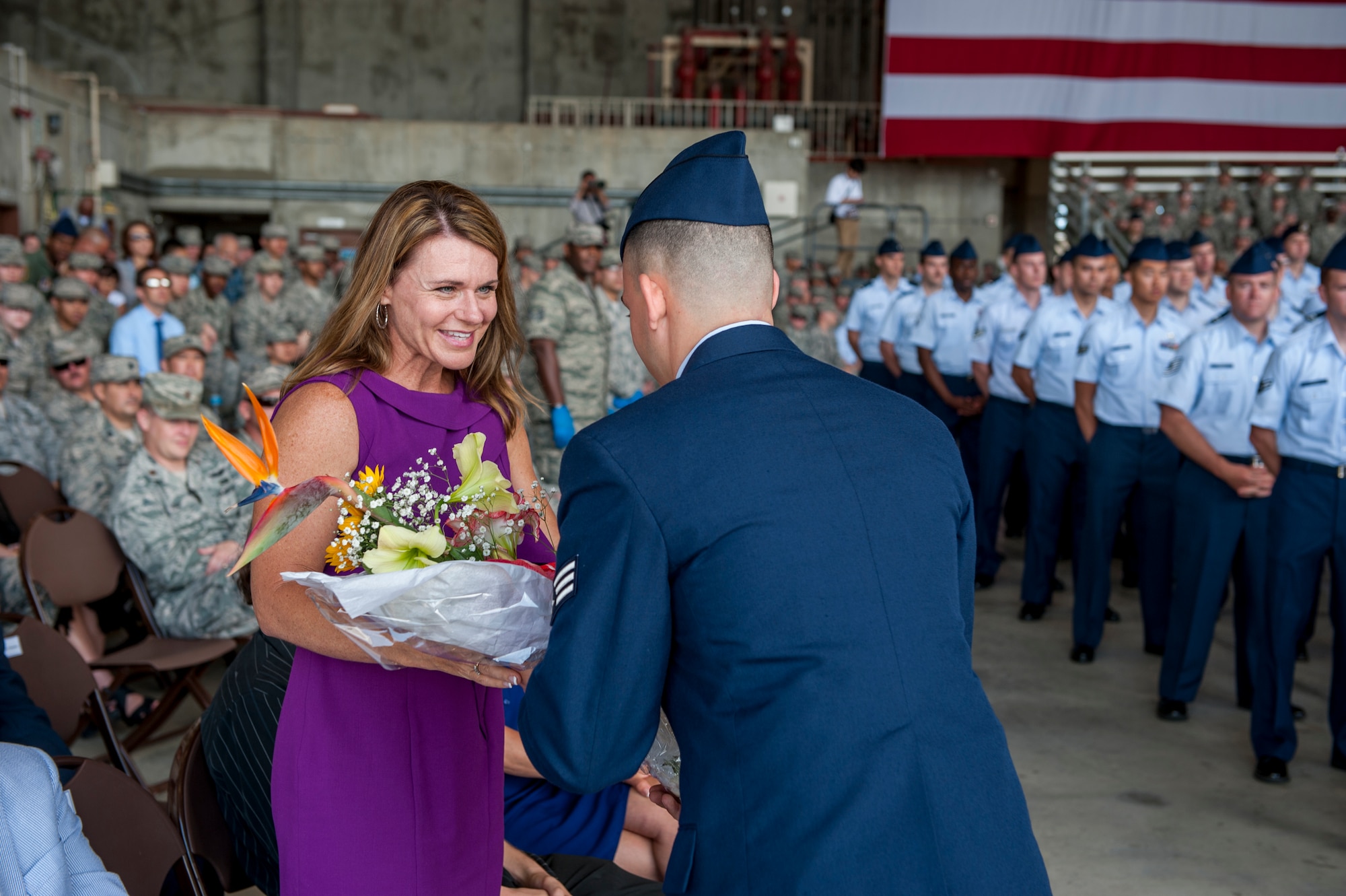 U.S. Air Force Brig. Gen. Barry Cornish’s wife, Missy, is given a bouquet of flowers to welcome her to the Team Kadena family during the 18th Wing change of command ceremony on Kadena Air Base, Japan, April 2, 2015. Cornish most recently served as an executive officer for Pacific Air Forces Command, Joint Base Pearl Harbor–Hickam, Hawaii. (U.S. Air Force photo by Airman 1st Class Stephen G. Eigel)