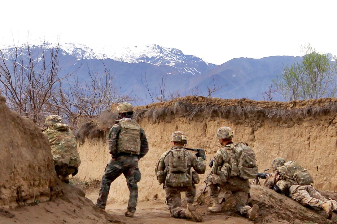 U.S. soldiers set up a defensive position after observing suspicious activity while patrolling through a village near Bagram Airfield, Afghanistan, March 24, 2015.
