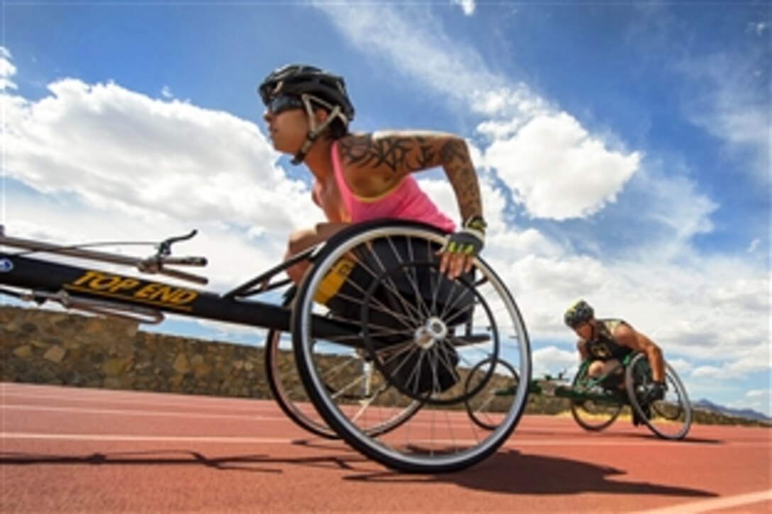 Army Staff Sgts. Monica Martinez, left, and Vestor ‘Max’ Hasson compete in separate 1,500-meter wheelchair race categories during the Army Trials on Fort Bliss in El Paso, Texas, April 1, 2015. Athletes in the trials are competing for a spot on the Army’s team in the 2015 Department of Defense Warrior Games.