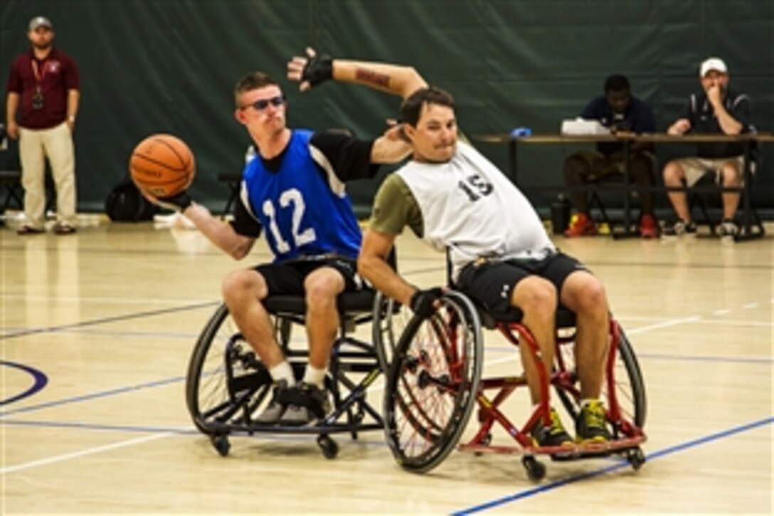 Army veteran Spc. Jason Blair, left, tries to pass around his defender during the wheelchair basketball bronze medal game during the 2015 Army Trials on Fort Bliss in El Paso, Texas, March 31, 2015. Athletes in the trials are competing for a spot on the Army’s team in the 2015 Department of Defense Warrior Games.