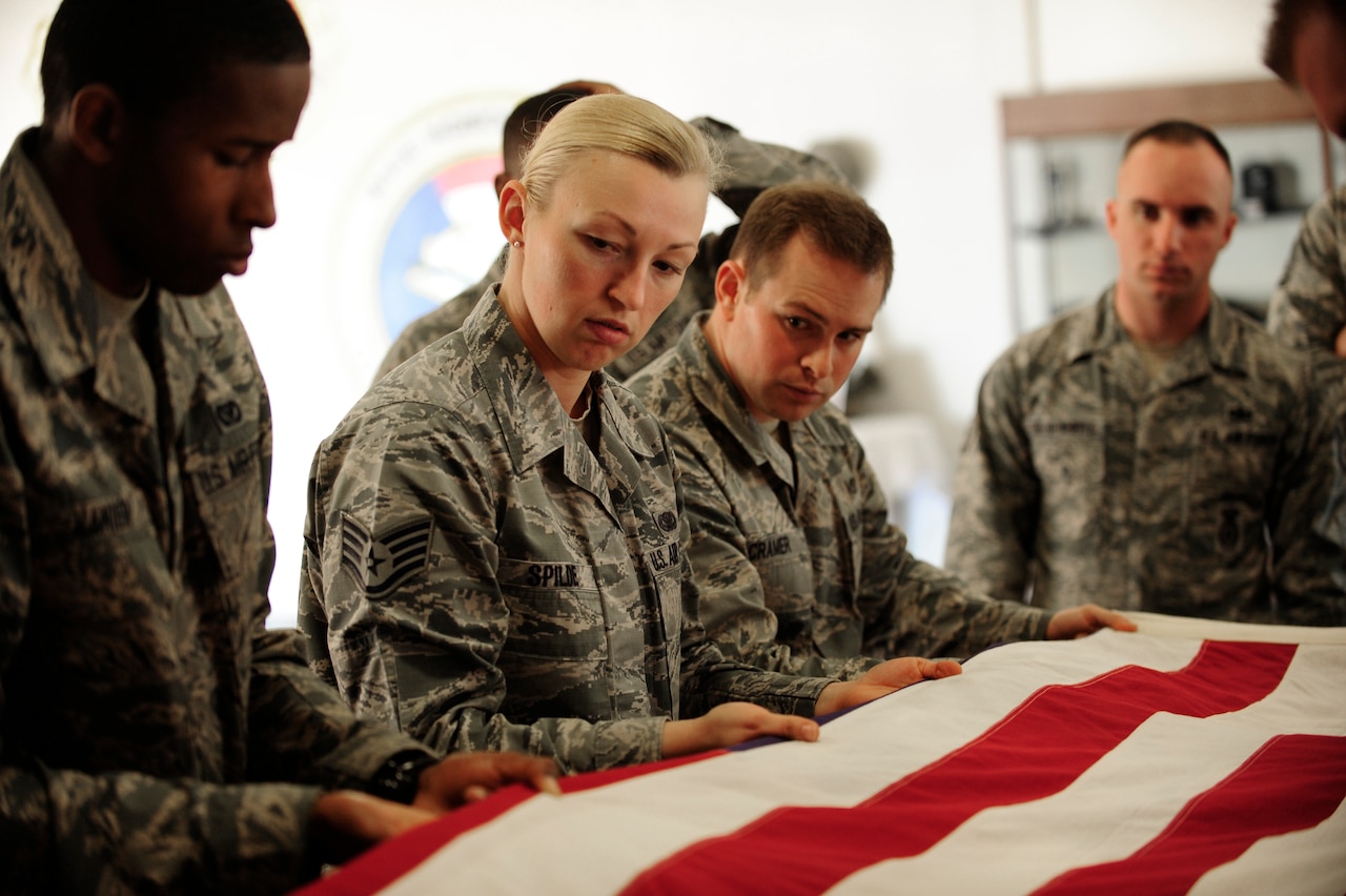 Staff Sgt. April Spilde, U.S. Air Force Honor Guard training instructor, trains new honor guardsmen how to perform a flag folding detail March 25, 2015, Vandenberg Air Force Base, Calif. Members of the Air Force Honor Guard from Joint Base Anacostia-Bolling, D.C. regularly provide specialized training to base level honor guard members. (U.S. Air Force photo by Staff Sgt. Jim Araos/Released)
