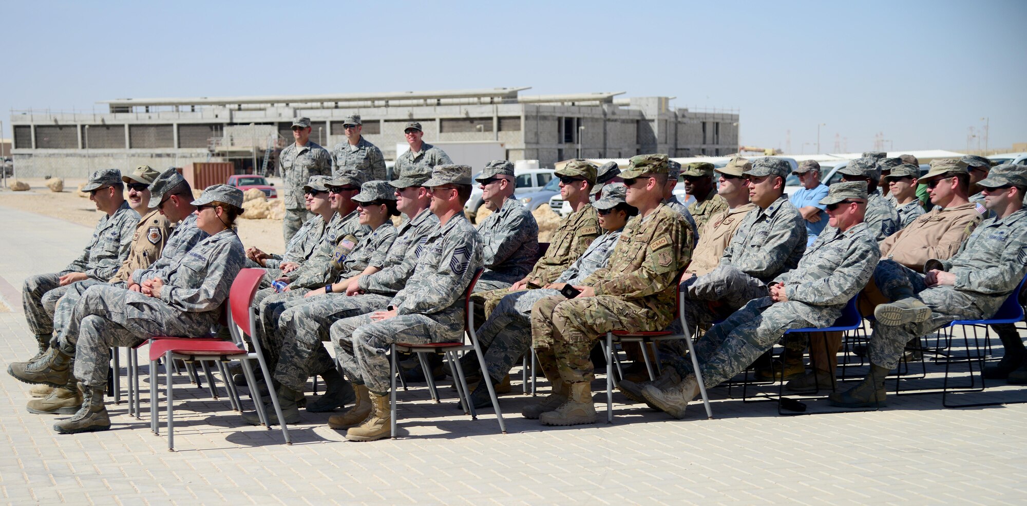 Attendees of the Blatchford-Preston Complex Phase II linen cutting ceremony listen to remarks before the grand opening of the new dormitories, April 3, 2015, at Al Udeid Air Base, Qatar. The opening of the BPC Phase II dormitories will make room for over 700 noncommissioned officers here at Al Udeid. (U.S. Air Force photo by Senior Airman Kia Atkins)
