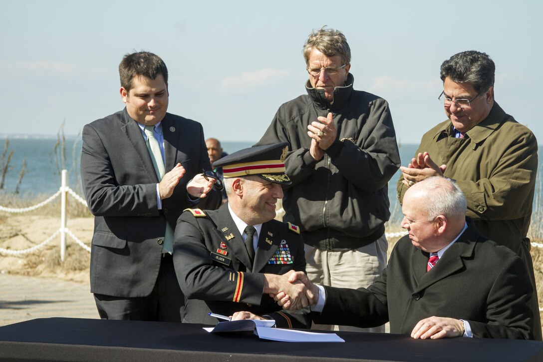 NORFOLK, Va. – Col. Paul Olsen, Norfolk District commander, and Paul Fraim; mayor of Norfolk, Virginia; sign an agreement combat sea-level rise as members of the Norfolk City Council look on March 30, 2015. The agreement paves the way for construction of a coastal storm damage reduction project, which is unprecedented in the 333-year history of the city of Norfolk. The initial beach nourishment will expand the width of roughly seven miles of the beach by 60-feet in the Willoughby Spit and East Ocean View areas. (U.S. Army photo/Mark Haviland)
