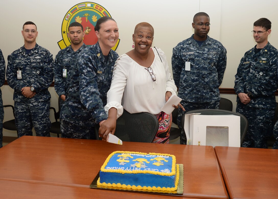 Flanked by sailors and civilian personnel, Chief Petty Officer Denise Galvan and Linda Lewis, chief hospital corpsman, Preventive Medicine, USN, retired, participate in a cake-cutting ceremony at the Naval Branch Health Clinic, Albany, April 1. The event, which was held at Marine Corps Logistics Base Albany, commemorated the 122nd anniversary since the Navy's chief petty officers' enlisted rank was established.