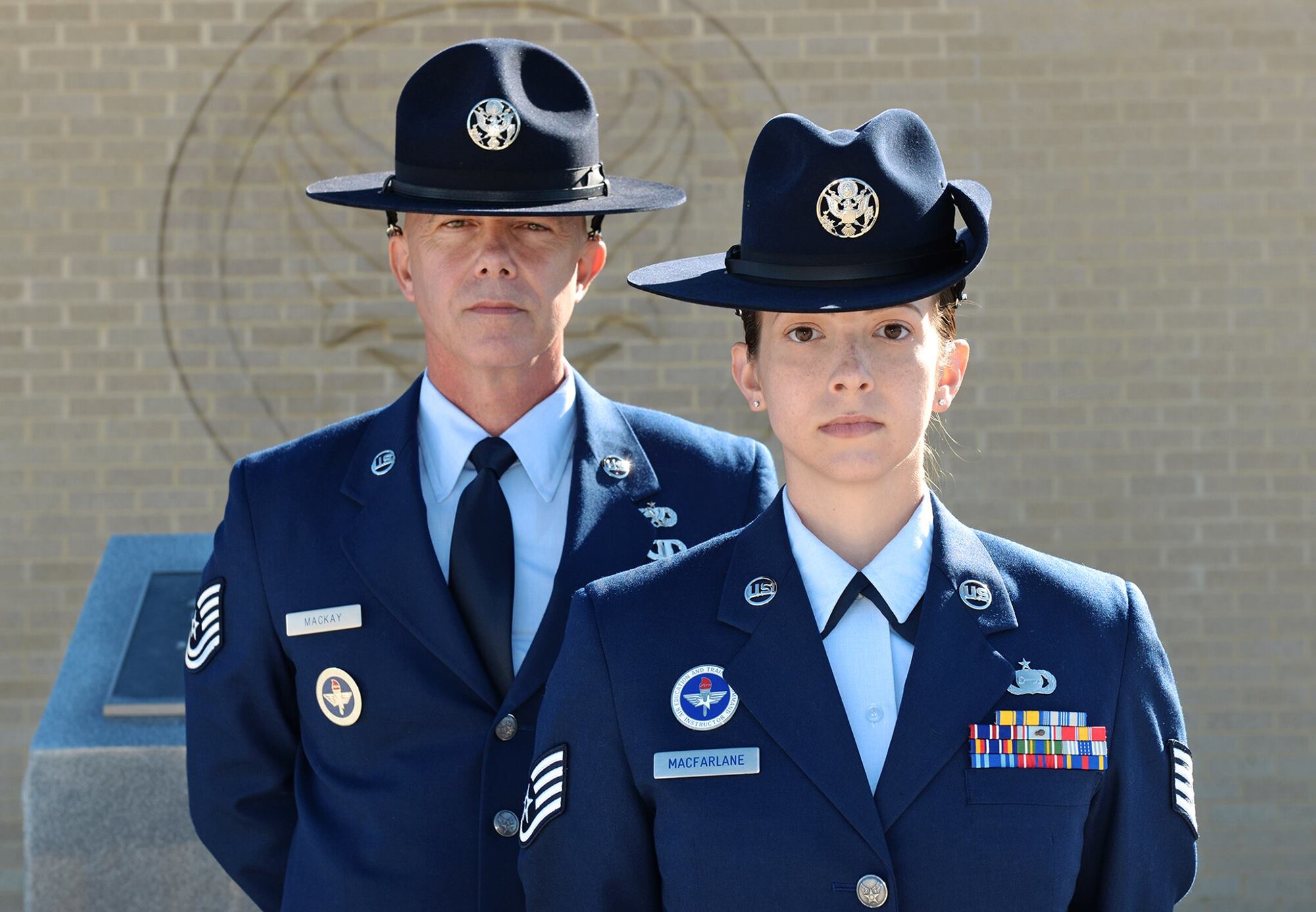 Tech. Sgt. James MacKay and his daughter, Staff Sgt. Amanda MacFarlane, 433rd Training Squadron military training instructors (MTI), pose for a photo on March 27, 2015, at Joint Base San Antonio-Lackland, Texas. MacKay and MacFarlane are the first father and daughter duo serving as MTIs at the same time. (U.S. Air Force photo/Benjamin Faske)