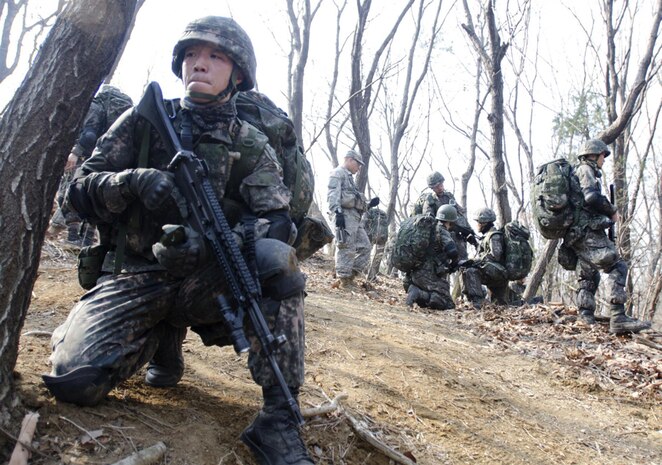 CAMP CASEY, South Korea (Mar. 27, 2015) - Cadet Huh Choong-bum (left), a third-year cadet at the Korea Military Academy (KMA), pulls a guard around his fellow soldiers as they examine the map during the land navigation training. The 1st Armored Brigade Combat Team, 2nd Infantry Division Soldiers trained and mentored KMA cadets in preparation for the Sandhurst Military Skills Competition at U.S. Military Academy at West Point, N.Y., April 10-11. 