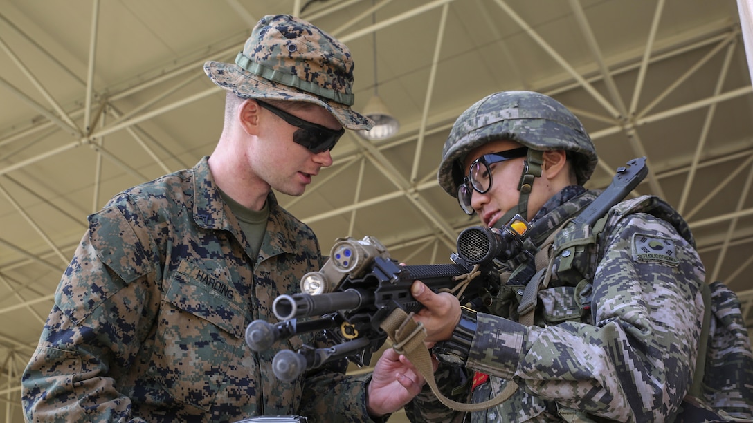 U.S. Marine Corps Lance Cpl. Thomas Harding shows a Republic of Korea Marine his M27 infantry automatic rifle during Korean Marine Exchange Program 15 in the vicinity of Pohang, South Korea, March 29, 2015. The 31st Marine Expeditionary Unit participated in KMEP 15. The overall objective of KMEPs are to enhance amphibious operations between ROK and U.S. forces that contributes to security and stability on the Korean Peninsula as well as the entire Asia-Pacific region.  The ROK Marines are with 33rd Battalion, 1st ROK Marine Division, and the U.S. Marines are with Company E, Battalion Landing Team 2nd Battalion, 4th Marines, 31st MEU. 