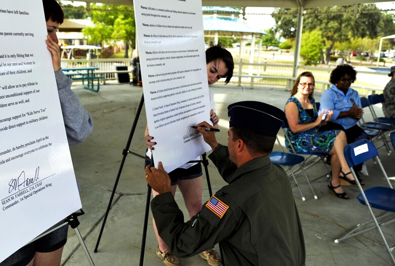 Col. Sean Farrell, 1st Special Operations Wing commander, signs a proclamation proclaiming April as Child Abuse Prevention Month for Hurlburt Field during the Month of the Military Child and Child Abuse Prevention Month kickoff at Hurlburt Field, Fla., April 1, 2015. Additionally, Farrell signed a proclamation proclaiming April as Month of the Military Child. (U.S. Air Force photo/Staff Sgt. Katherine Holt)