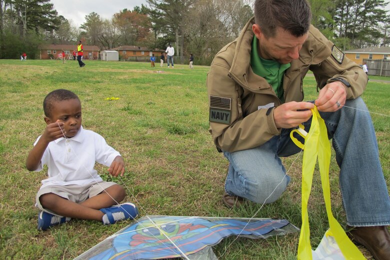 Wesley Malone, a project manager with the Army Corps of Engineers Huntsville Center, helps Rolling Hills student maintain a kite.