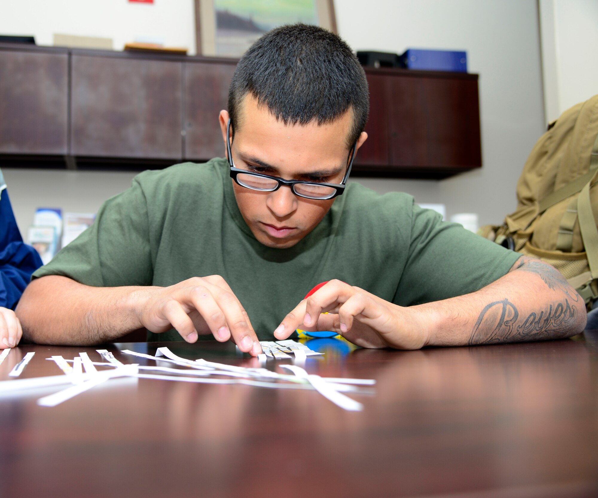 U.S. Air Force Airman 1st Class Daniel Reyes, a 354th Security Forces Squadron response force member, pieces together strips of paper to make a map during the 354th Fighter Wing “Amazing Rac”’ at Eielson Air Force Base, Alaska, April 3, 2015. The race kicked off the Sexual Assault Awareness and Prevention Month. (U.S. Air Force photo by Senior Airman Racheal E. Watson/Released) 