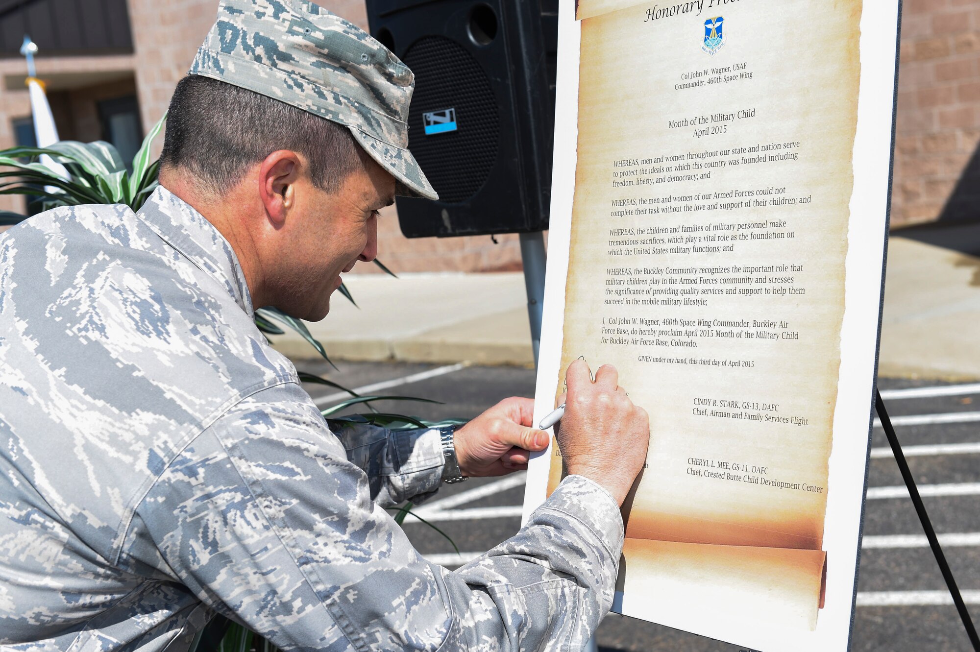 Col. John Wagner, 460th Space Wing commander, signs the Month of the Military Child honorary proclamation April 3, 2015, at the Crested Butte Child Development Center on Buckley Air Force Base, Colo. The proclamation officially cited April as Month of the Military Child. (U.S. Air Force photo by Airman 1st Class Samantha Saulsbury/Released)