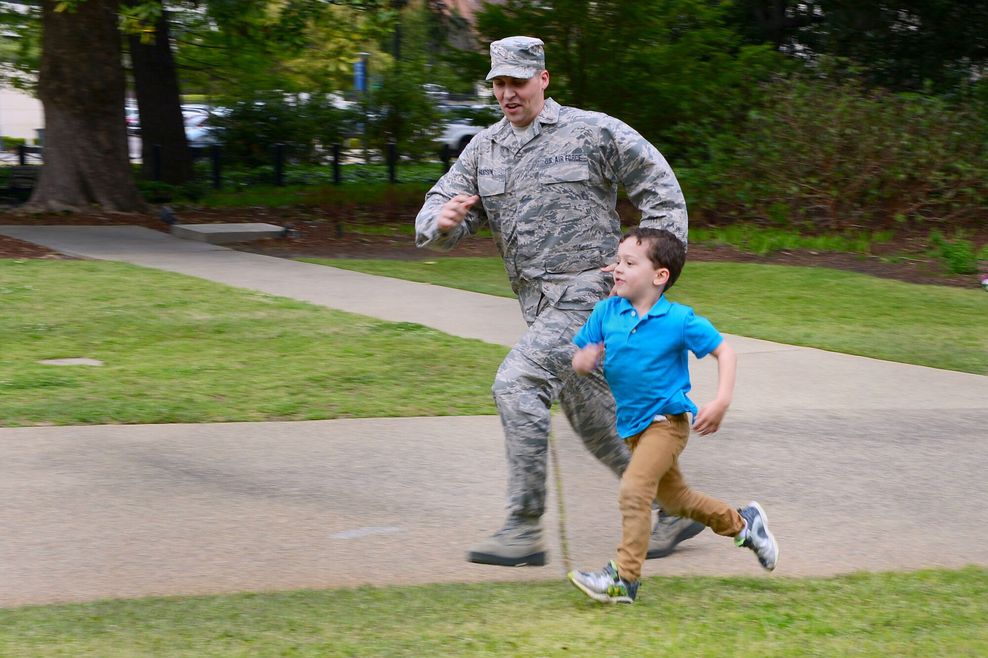 Air National Guard 2nd Lt. Stephen Hudson, 169th Fighter Wing public affairs officer, runs with his son Parker outside the Statehouse in Columbia S.C., April 2, 2015. Hudson and his son attended the Month of the Military Child Proclamation reading by South Carolina Governor Nikki Haley. (U.S. Air Force photo by Senior Airman Jensen Stidham/Released) 