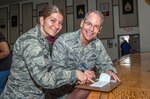 Brig. Gen. Bob LaBrutta, 502nd Air Base Wing and Joint Base San Antonio commander, fills out a 2015 Air Force Assistance Fund Campaign form as Capt. Enisa Dervisevic, JBSA-Fort Sam Houston instalation project officer, looks on.  The Air Force Aid Society provides Airmen and their families worldwide with emergency financial assistance, education assistance and various base-level community enhancement programs. (U.S. Air Force photo by Johnny L. Saldivar)