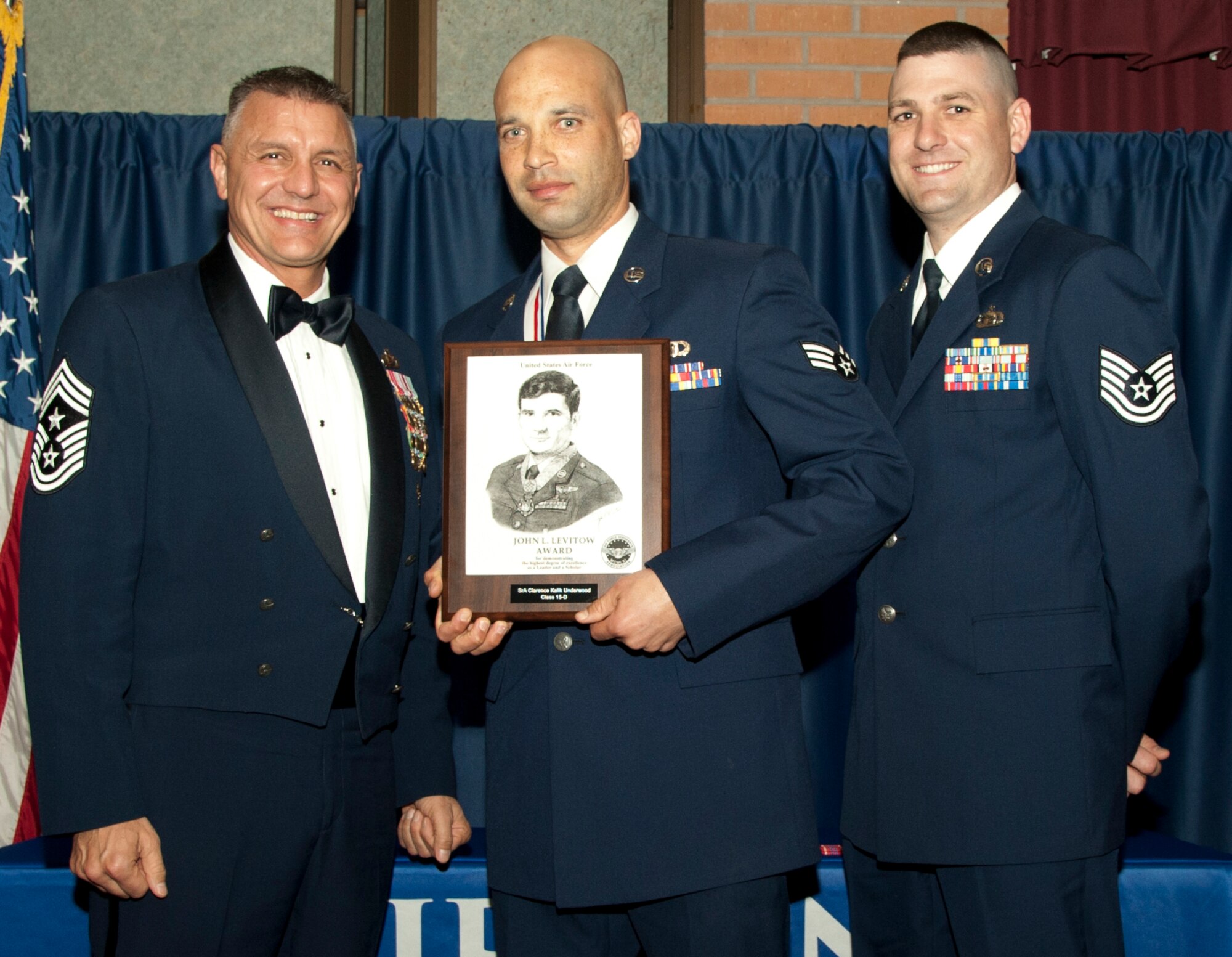 Senior Airman Jeremy Kalik-Underwood, from the 71st Operations Support Squadron, is presented the John L. Levitow Award by Command Chief Master Sgt. Peter Speen, the 71st Flying Training Wing command chief, and Tech. Sgt. James Bolinger, the 71st FTW Public Affairs Office NCO in-charge, March 25 during the first-ever Airman Leadership School graduation at Vance in the Vance Collocated Club. Bolinger was representing the Air Force Sergeants Association Chapter 990 who sponsored the award. (U.S. Air Force photo\2nd Lt. Isabel Crump)