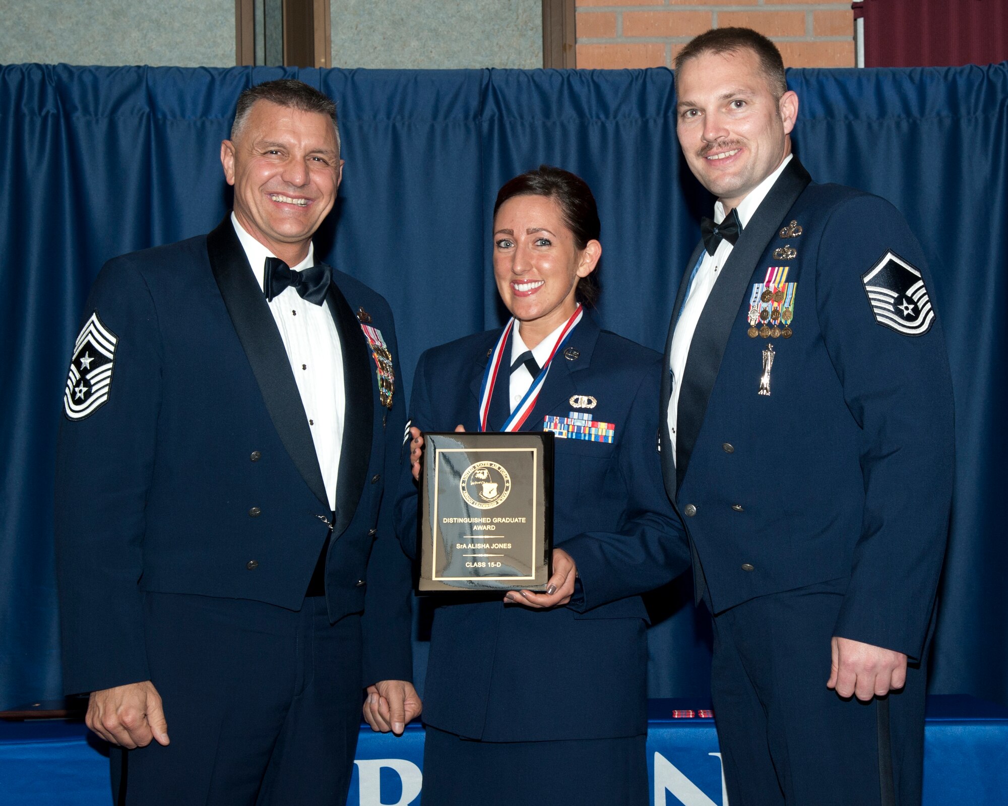 Senior Airman Alisha Jones, from the 71st Operations Support Squadron, is recognized as the Distinguished Graduate by Command Chief Master Sgt. Peter Speen, the 71st Flying Training Wing command chief, and Master Sgt. Jon Dalton, from the 71st OSS, March 25 during the first-ever Airman Leadership School graduation at Vance in the Vance Collocated Club. Dalton was representing the Silver Talon Top 3 who sponsored the award. (U.S. Air Force photo\ 2nd Lt. Isabel Crump)
