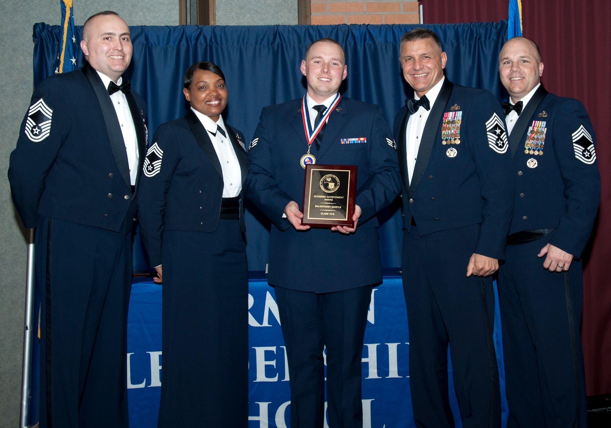 Senior Airman Anthony Marple, from the 71st Operation Support Squadron receives the Academic Award from members of the Vance Chief’s Group March 25 during the first-ever Airman Leadership School graduation at Vance in the Vance Collocated Club. Representing the Chief’s Group were (left to right) Chief Master Sgt. Bruce McPherson, 71st Security Forces Squadron, Chief Master Sgt. Melvina Smith, 71st Mission Support Group, Command Chief Master Sgt. Peter Speen, the 71st Flying Training Wing command chief, and Chief Master Sgt. Kraig Chapman, 71st OSS. (U.S. Air Force photo\ 2nd Lt. Isabel Crump)