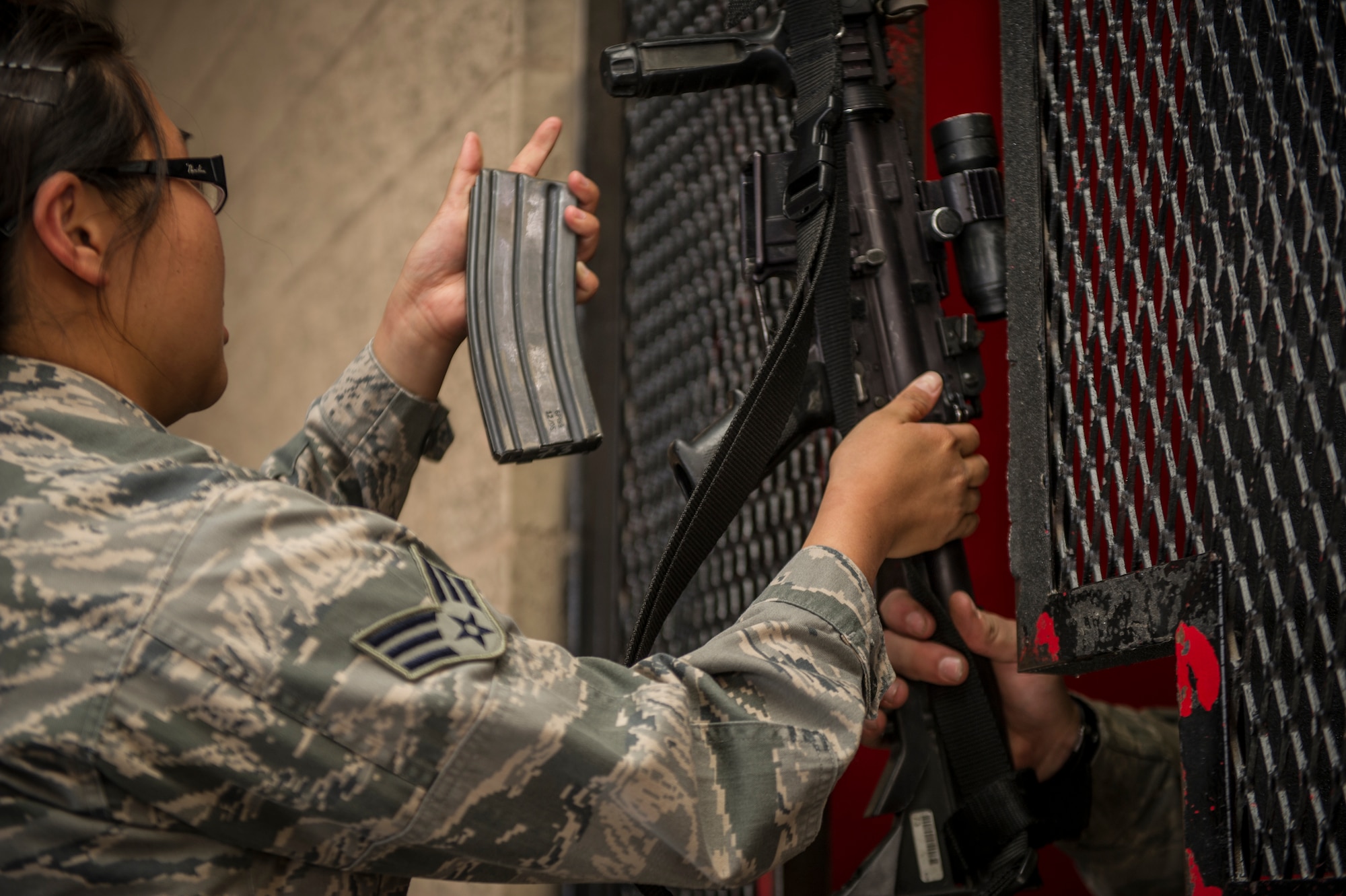 Senior Airman Ginger Lewis, 49th Security Forces Squadron patrolman, returns her M-4 Carbine to Senior Airman Tyrus Wilcox, 49th SFS daytime armorer, after completing her shift at Holloman Air Force Base, N.M., April 2, 2015. The armory issues weapon systems to the individual SF members that are coming to and from work, their equipment and anything else they need for the day. The weapons are also inspected to ensure they are in proper working order for the next recipient. (U.S. Air Force photo by Airman 1st Class Aaron Montoya / Released)