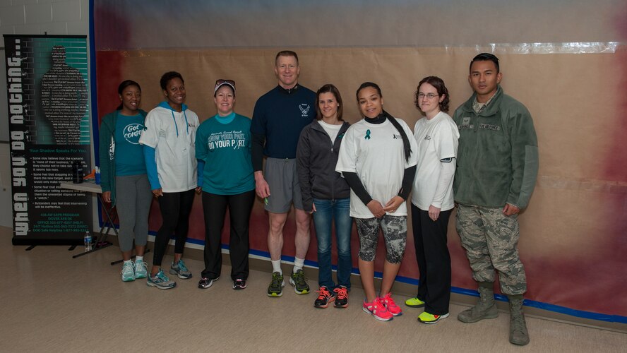 Col. Michael Grismer, 436th Airlift Wing commander, poses with Team Dover’s Sexual Assault Prevention and Response victim advocates in front of the Sexual Assault Awareness and Prevention Month Graffiti Wall April 2, 2015, at the fitness center on Dover Air Force Base, Del. Victim advocates are a support system for victims of sexual assault. (U.S. Air Force photo/Airman 1st Class Zachary Cacicia)