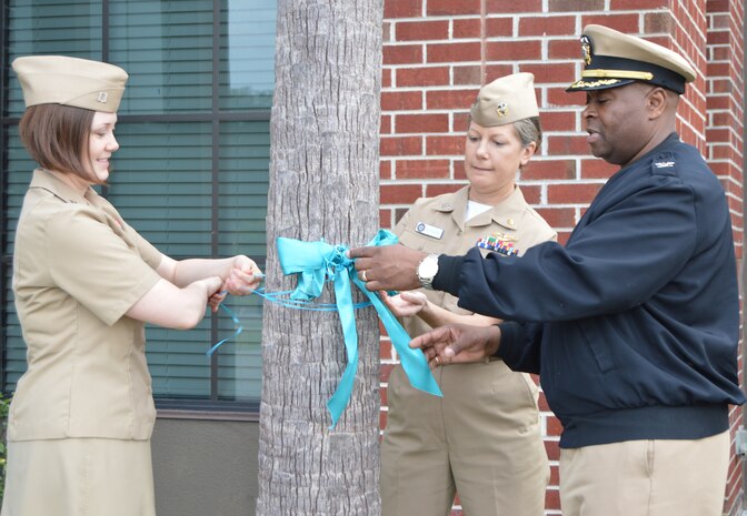 Naval Health Clinic Charleston commanding officer Capt. Marvin Jones, right, Lt. Nikki Pritchard, NHCC Sexual Assault Prevention and Response point of contact ,left, and Lt. Kristin Aucker, center, alternate NHCC SAPR POC, tie a teal ribbon on a tree in front of NHCC, Joint Base Charleston, S.C., April 3, 2015 in recognition of Sexual Assault Awareness Month. Throughout April, NHCC staff members commit to raising awareness about sexual assault prevention. (U.S. Navy photo/Kris Patterson)
