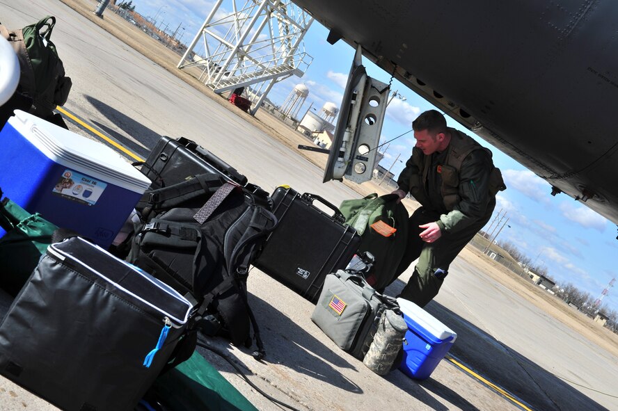 A B-52H Stratofortress crewmember loads gear into a B-52 before a training mission on Minot Air Force Base, N.D., April 1, 2015. The training mission, coined “POLAR GROWL”, aims to provide unique training opportunities while testing the bomber force’s command and control apparatus’ ability to support two synchronized flight paths. (U.S. Air Force photos/Senior Airman Malia Jenkins)