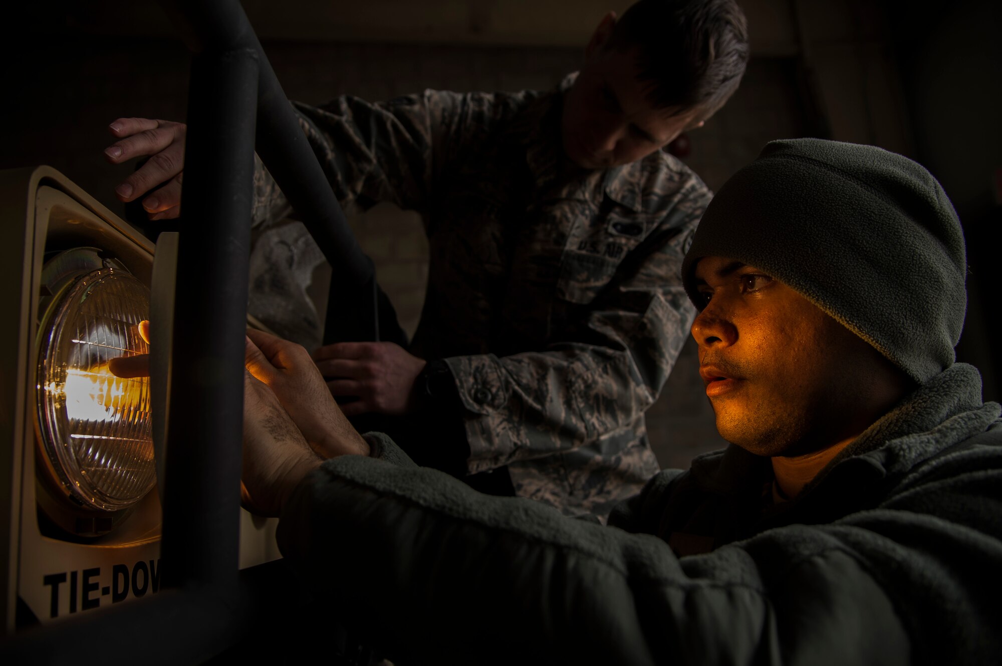 Senior Airman Christopher Good, 818 Contingency Response Group, replaces a headlight on a vehicle as Senior Airman James Griffin, 818 CRG, helps hold it in place during the Devil Raid Mobility Exercise competition at Joint Base McGuire-Dix-Lakehurst, N.J., March 31, 2015. The 570 and 571 CRGs stationed at Travis Air Force Base, Calif., are both scheduled to conduct their mobility exercise competition April 27. (U.S. Air Force photo/Staff Sgt. Gustavo Gonzalez/RELEASED)
