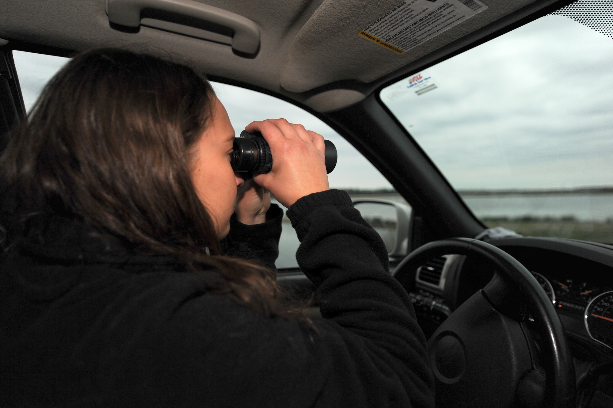 Samantha Whitworth, U.S. Department of Agriculture Animal and Plant Health Inspection Service wildlife specialist, scans the horizon for birds March 30, 2015, at the City of Goldsboro Water Reclamation Facility, North Carolina. The facility’s water, which covers approximately 200 acres of land, attracts various species of birds, a hazard to aircraft. (U.S. Air Force photo/Airman 1st Class Aaron J. Jenne)