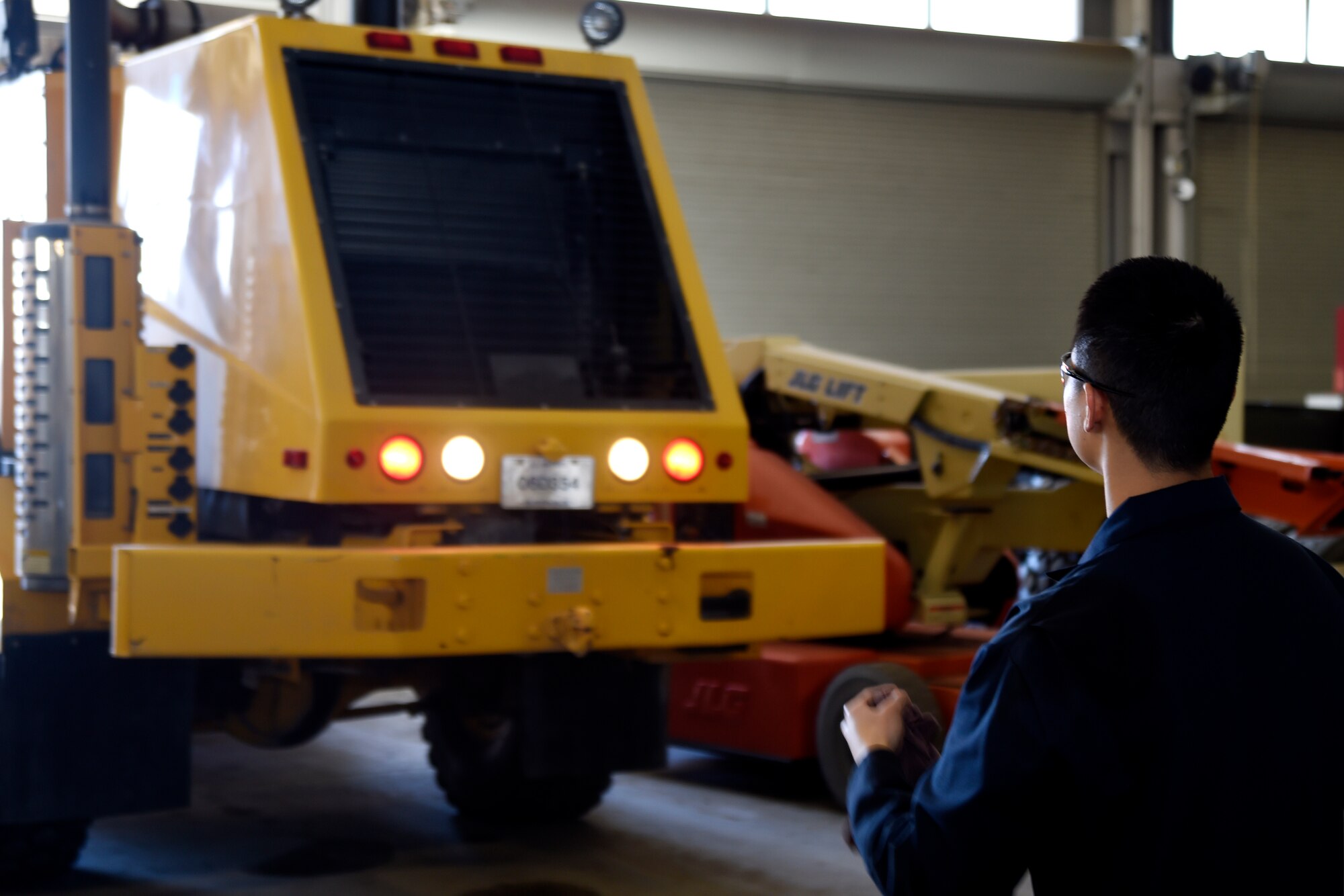 Airman Yoon Kim, 11th Logistics Readiness Squadron vehicle maintainer, guides a truck driver into a hangar at Joint Base Andrews, Md., April 2, 2015. Kim and the driver finished performing a vehicle operations check to ensure the truck was running properly and safely. (U.S. Air Force photo/Airman 1st Class Ryan J. Sonnier)