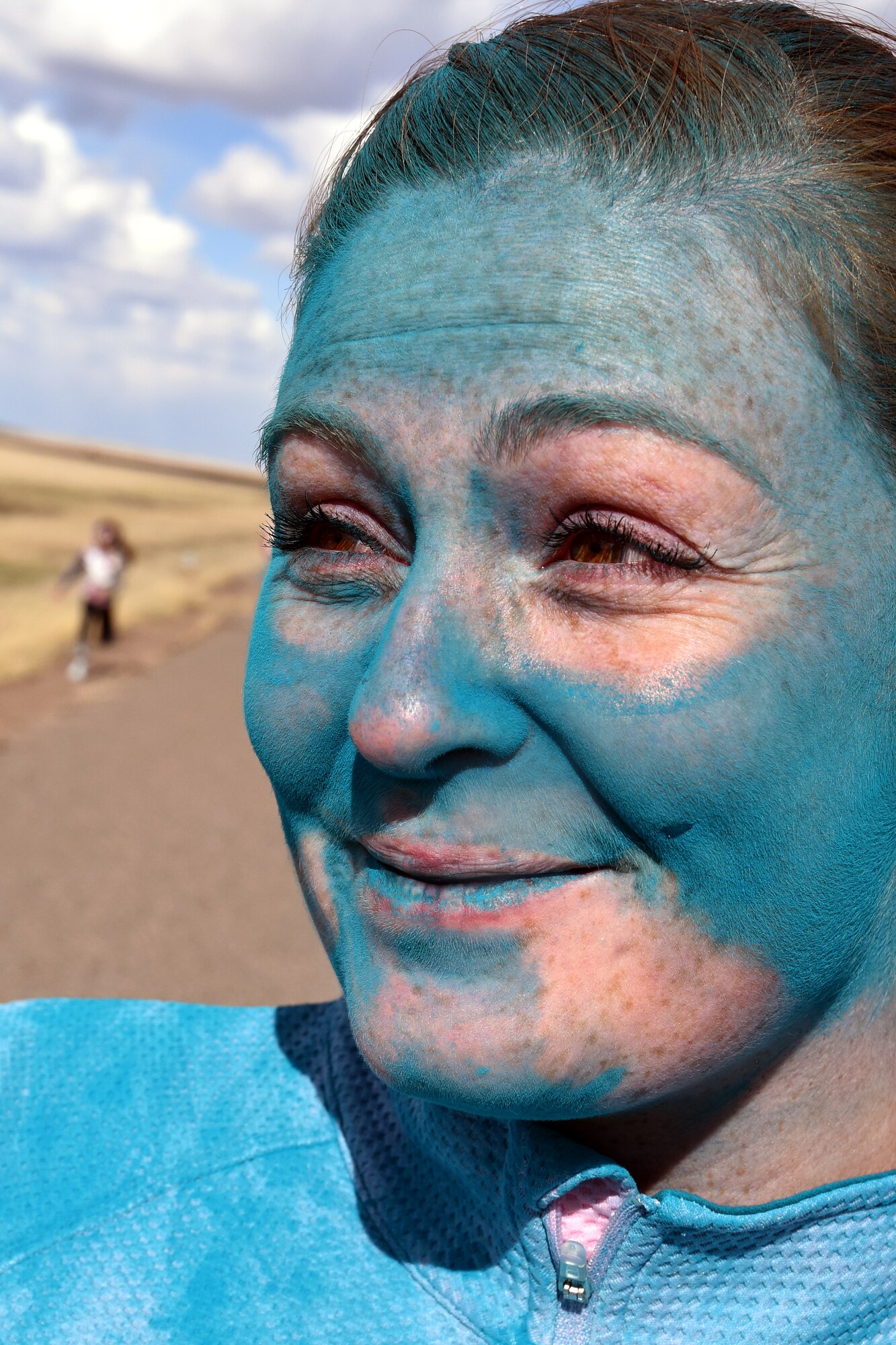 Airman 1st Class Bailee Bileschi, 341st Security Forces Squadron, gets covered by powdered paint at the blue station during the Wingman Month kickoff color run April 1, 2015 at Malmstrom Air Force Base, Mont. The blue station, one of four set up around the 1.7 mile course, represented Child Abuse Prevention Month. (U.S. Air Force photo/Chris Willis)