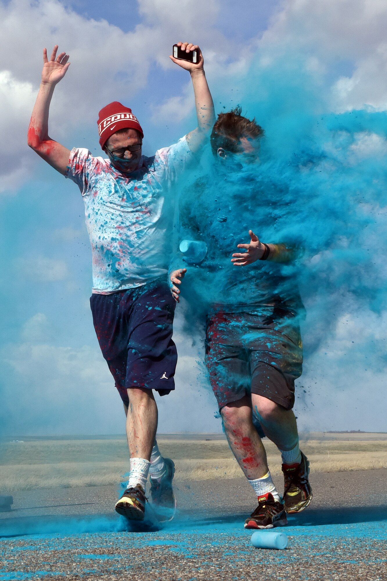 Team Malmstrom members run past the blue station of the Wingman Month kickoff color run April 1, 2015 at Malmstrom Air Force Base, Mont. The blue station, one of four set up around the 1.7 mile course, represented Child Abuse Prevention Month. (U.S. Air Force photo/Chris Willis)