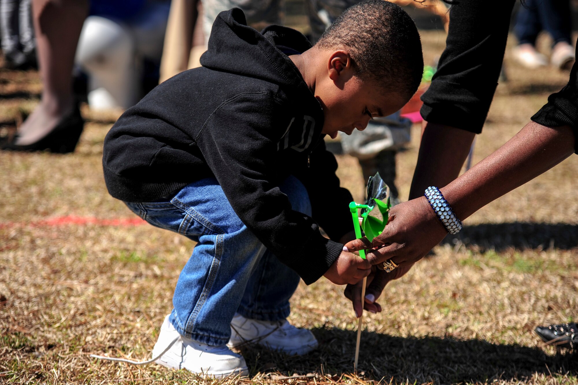 Members of Team Seymour plant pinwheels during a “Pinwheels for Child Abuse Prevention” event, April 1, 2015, at Seymour Johnson Air Force Base, North Carolina. The pinwheel stands as a symbol of hope for children across that nation that they will never endure abuse or neglect. (U.S Air Force photo/Senior Airman Brittain Crolley)