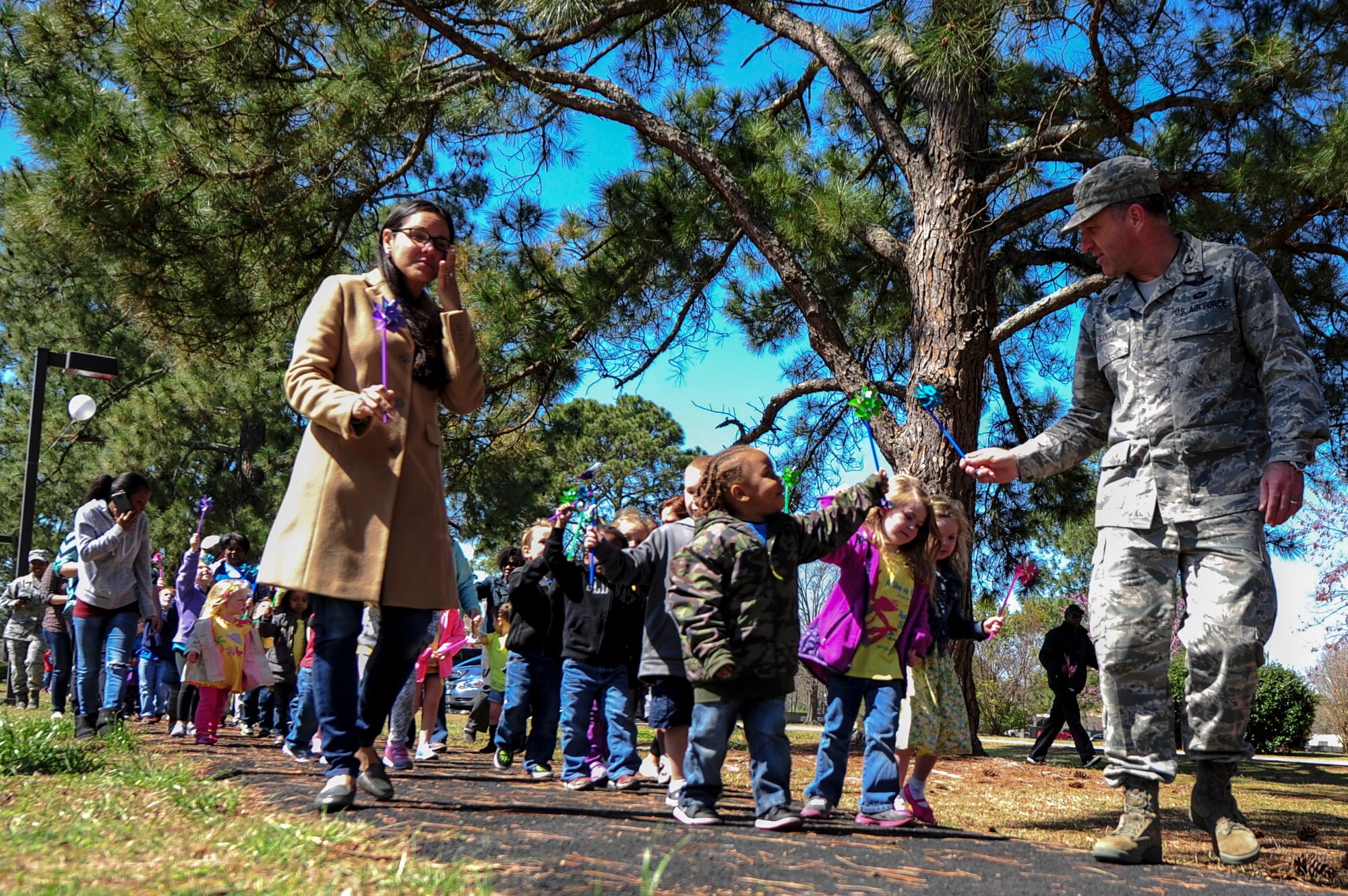 Col. Mark Slocum, 4th Fighter Wing commander, and his wife, Xavi, lead children on a walk to the pinwheel garden during a “Pinwheels for Child Abuse Prevention” event, April 1, 2015, at Seymour Johnson Air Force Base, North Carolina. The campaign works to ensure the healthy development of children nationwide. (U.S Air Force photo/Senior Airman Brittain Crolley)