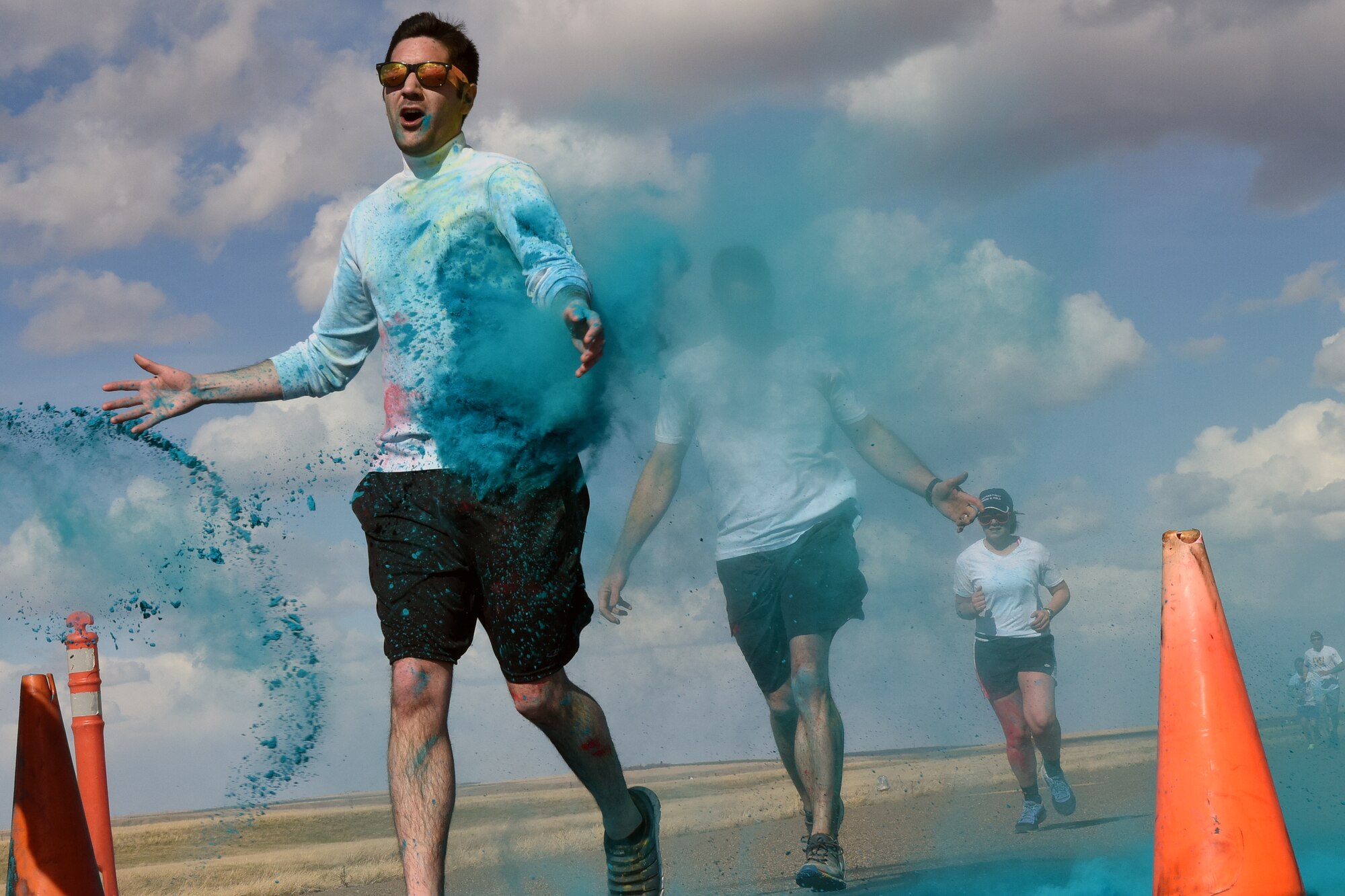 Team Malmstrom members run past the blue station of the Wingman Month kickoff color run April 1, 2015 at Malmstrom Air Force Base, Mont. The blue station, one of four set up around the 1.7 mile course, represented Child Abuse Prevention Month. (U.S. Air Force photo/Chris Willis)