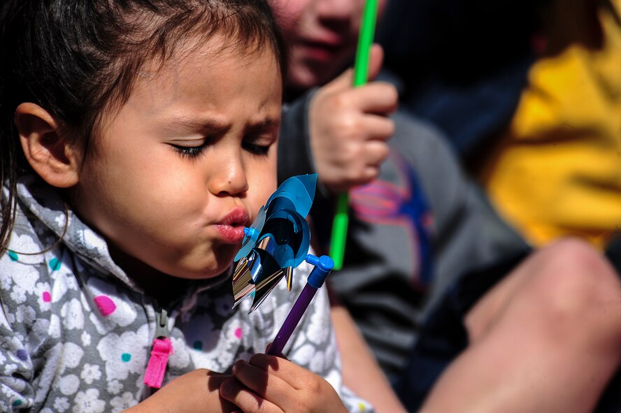 A child of Team Seymour blows on a pinwheel during a “Pinwheels for Child Abuse Prevention” event, April 1, 2015, at Seymour Johnson Air Force Base, North Carolina. The pinwheel is the national symbol for child abuse and neglect prevention. (U.S Air Force photo/Senior Airman Brittain Crolley)