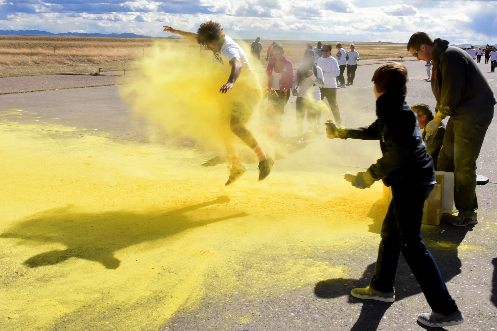 Team Malmstrom members run past the yellow station of the Wingman Month kickoff color run April 1, 2015 at Malmstrom Air Force Base, Mont. The yellow station, one of four set up around the 1.7 mile course, represented remembrance. (U.S. Air Force photo/Chris Willis)