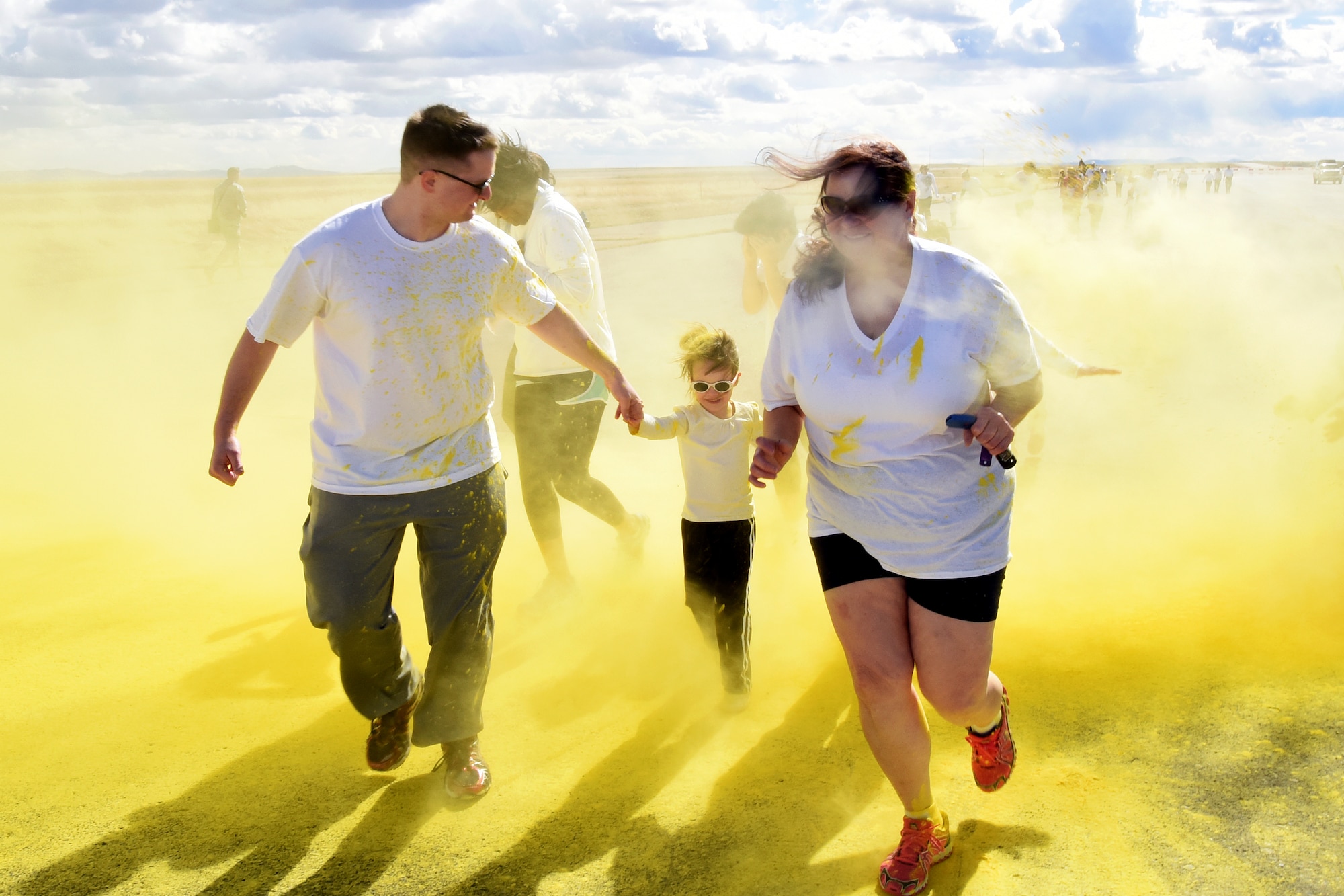 Team Malmstrom members run past the yellow station of the Wingman Month kickoff color run April 1, 2015 at Malmstrom Air Force Base, Mont. The yellow station, one of four set up around the 1.7 mile course, represented remembrance. (U.S. Air Force photo/Chris Willis)
