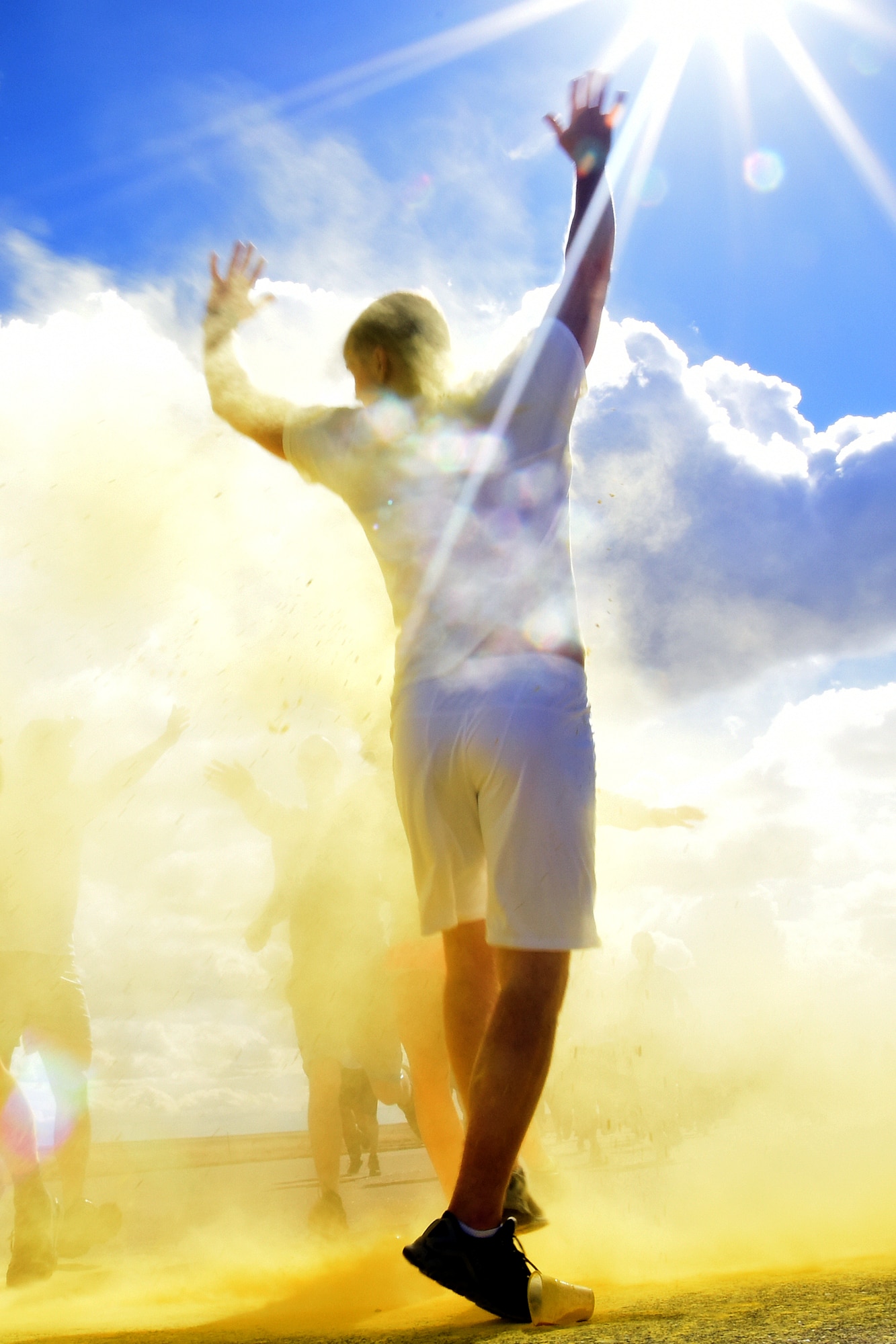 A Team Malmstrom member runs past the yellow station of the Wingman Month kickoff color run April 1, 2015 at Malmstrom Air Force Base, Mont. The yellow station, one of four set up around the 1.7 mile course, represented Remembrance. (U.S. Air Force photo/Chris Willis)