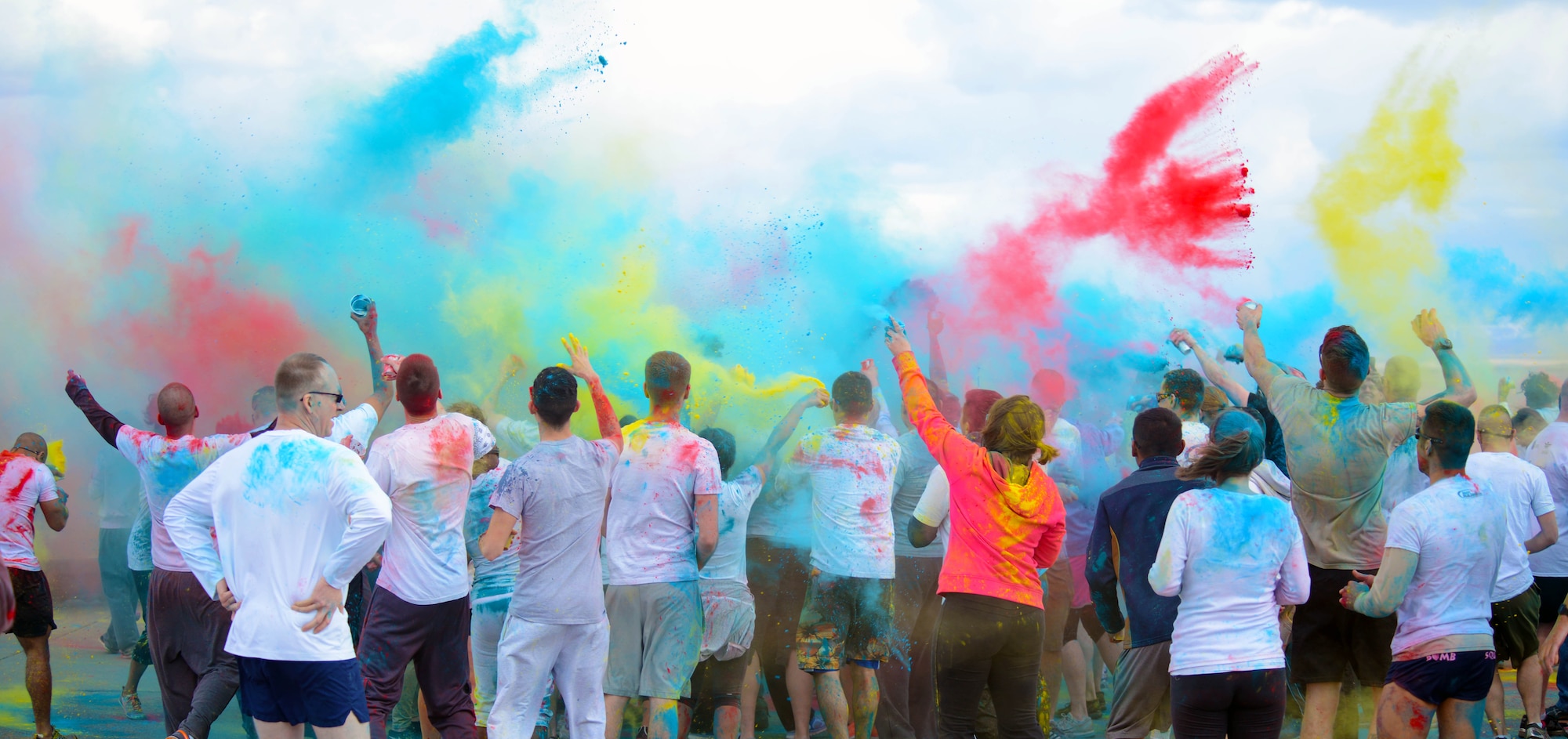 Team Malmstrom members throw cups of powdered paint in the air following a Wingman Month kickoff color run April 1, 2015, at Malmstrom Air Force Base, Mont. Each participant received a cup of their preferred color for a final celebration to maximize paint coverage on everyone in attendance. (U.S. Air Force photo/Airman 1st Class Dillon Johnston)