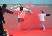 Two Team Malmstrom members run through the red paint station of the Wingman Month kickoff color run April 1, 2015, at Malmstrom Air Force Base, Mont. The red station, one of four set up around the 1.7 mile course, represented Comprehensive Airman Fitness. (U.S. Air Force photo/Airman 1st Class Dillon Johnston)