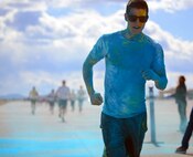 A Team Malmstrom member runs past the blue paint station of the Wingman Month kickoff color run April 1, 2015, at Malmstrom Air Force Base, Mont. The blue station, one of four set up around the 1.7 mile course, represented Child Abuse Prevention Month. (U.S. Air Force photo/Airman 1st Class Dillon Johnston)