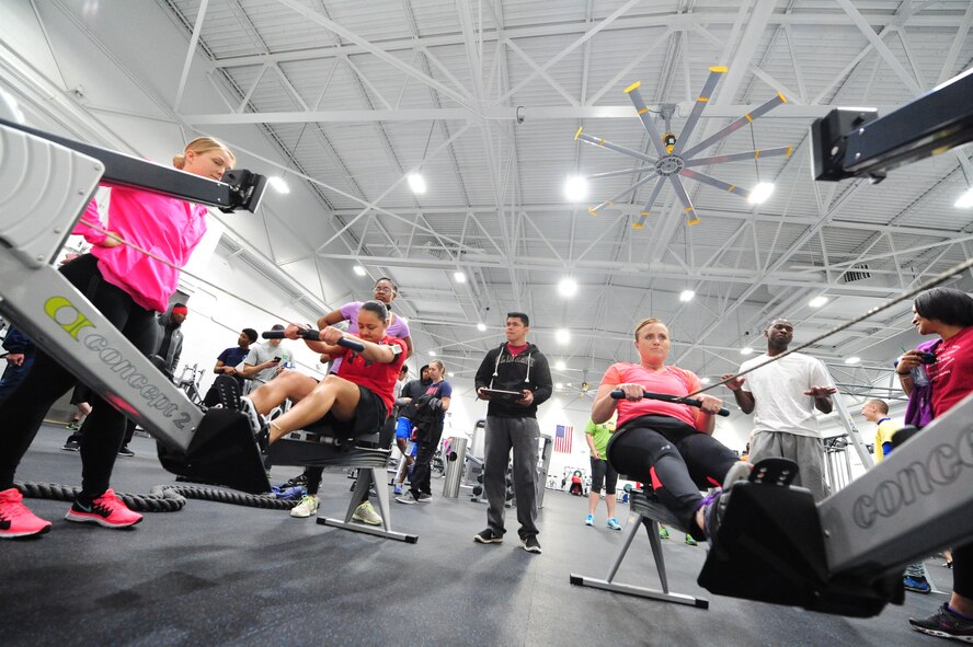 Senior Airman Nicole Cannon, 509th Security Forces Squadron patrolman, encourages Senior Airman Silvia Cortezlomas, 509th SFS security staff assistant, as she competes in a rowing competition against Tech. Sgt. Kim Stone, 442nd Maintenance Group unit training manager, in the fitness center at Whiteman Air Force Base, Mo., March 27, 2015. The rowing competition was held as part of the Whiteman Winter Olympics, where the organizations contended to be named as best of the best. The 509th SFS received the second place large squadron award with a total of 490 points from 18 events. (U.S. Air Force photo by Staff Sgt. Nick Wilson/Released)